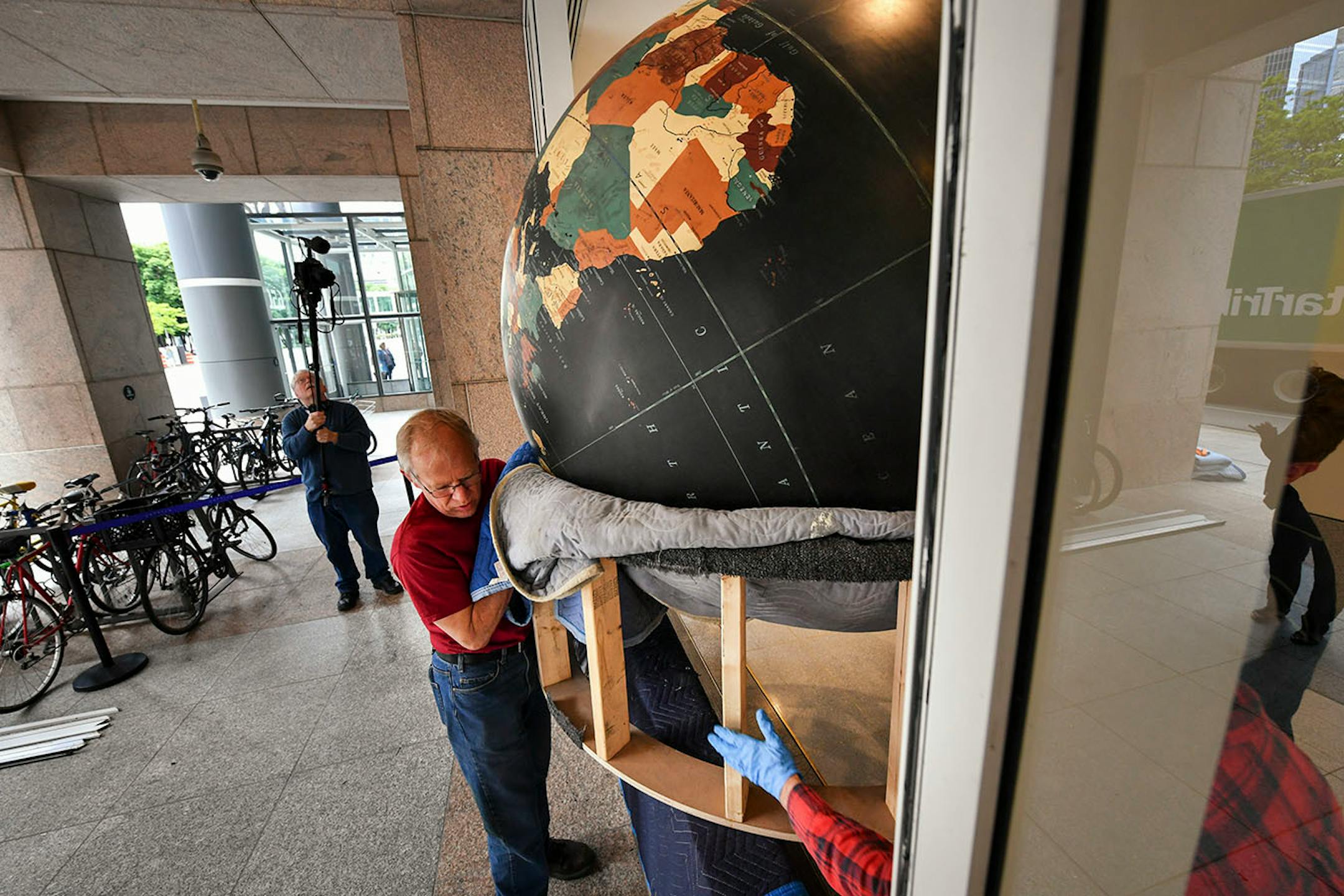 Workers from Blue Rhino Studio in Eagan carried the Star Tribune globe through a removed window.
