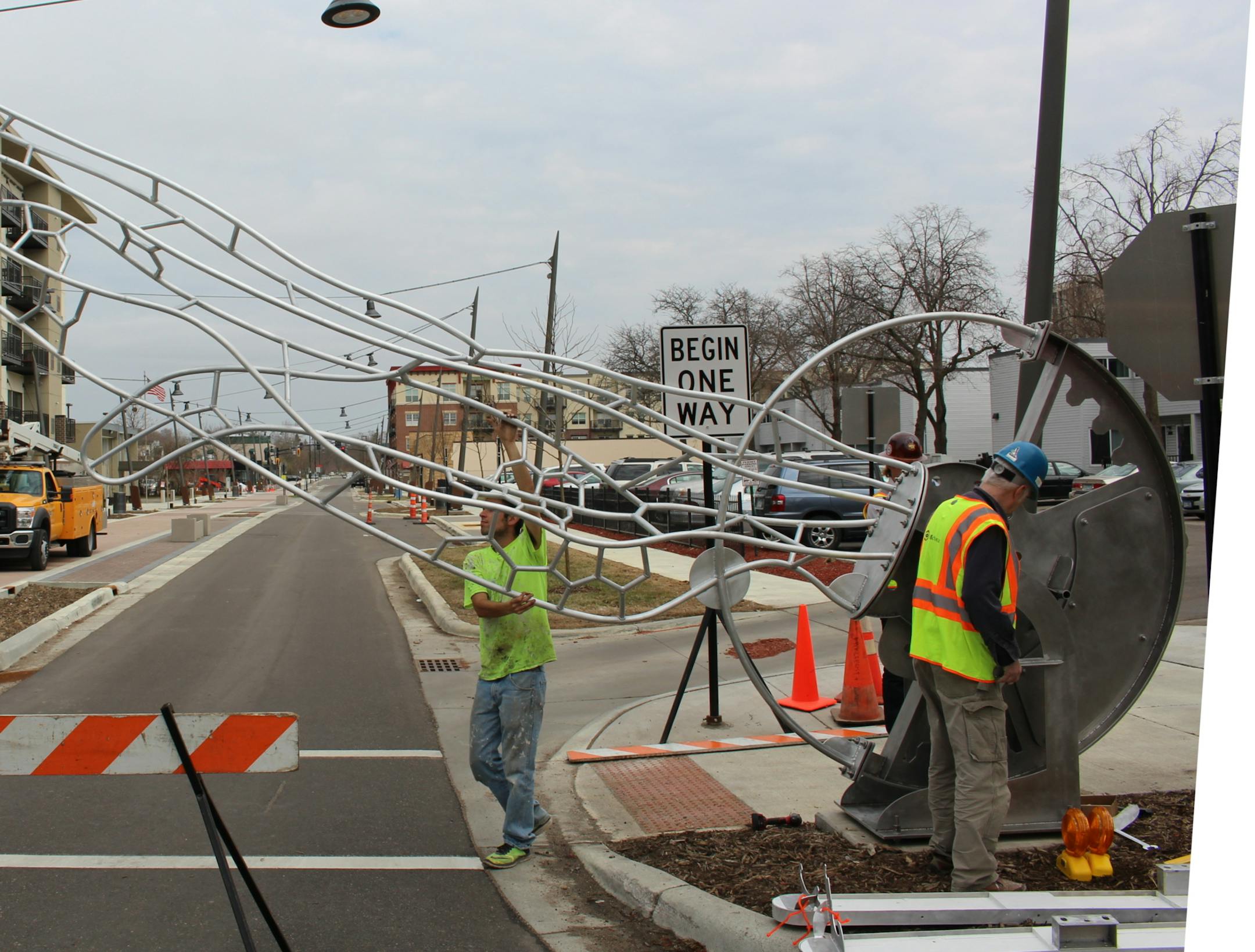 Grayson Sears lowers the newly installed dragonfly wing sculpture, which will serve as a piece of art and a traffic barrier during festivals.
