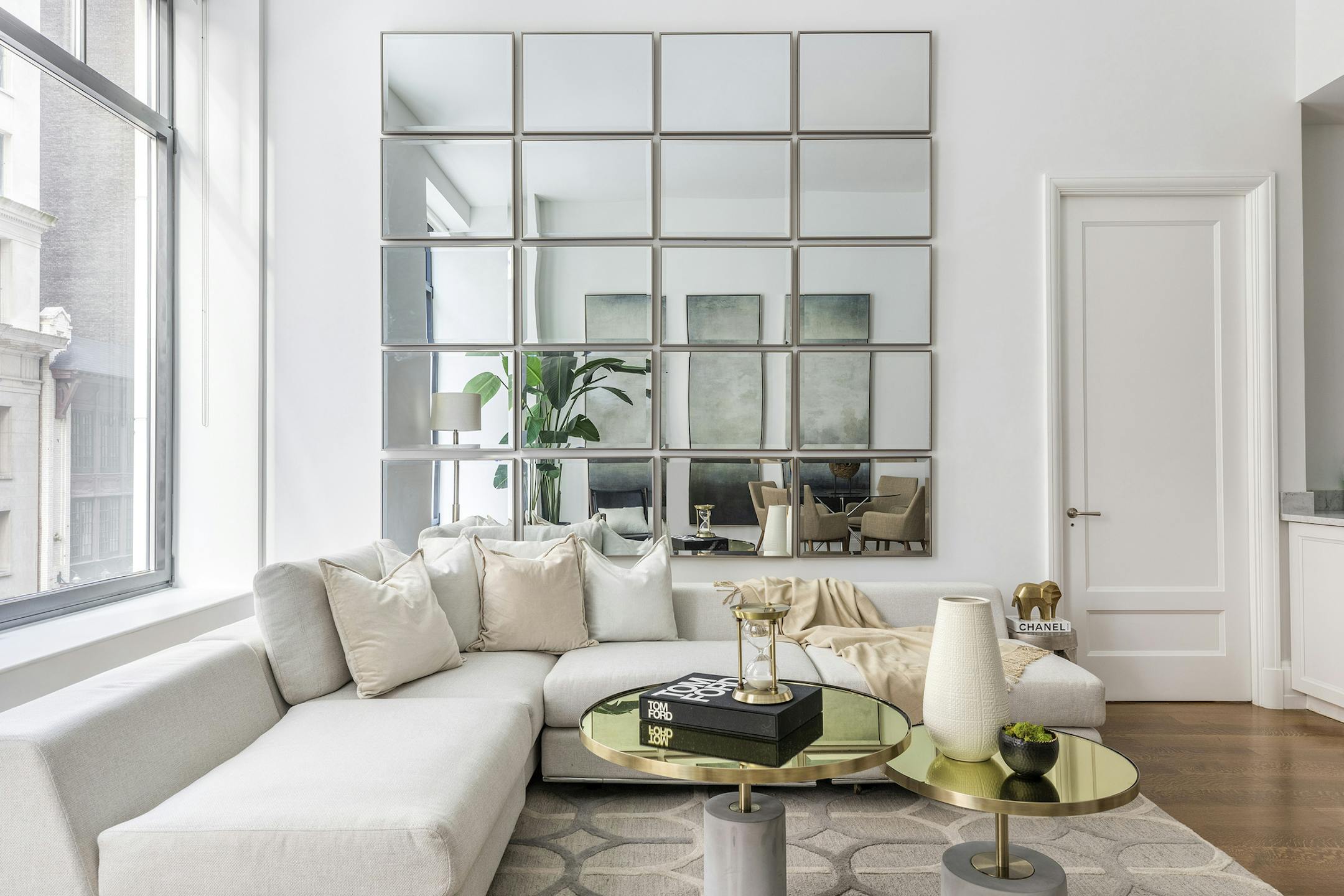 A wall of mirrors helps a small living room feel open and spacious. (Design Recipes)
