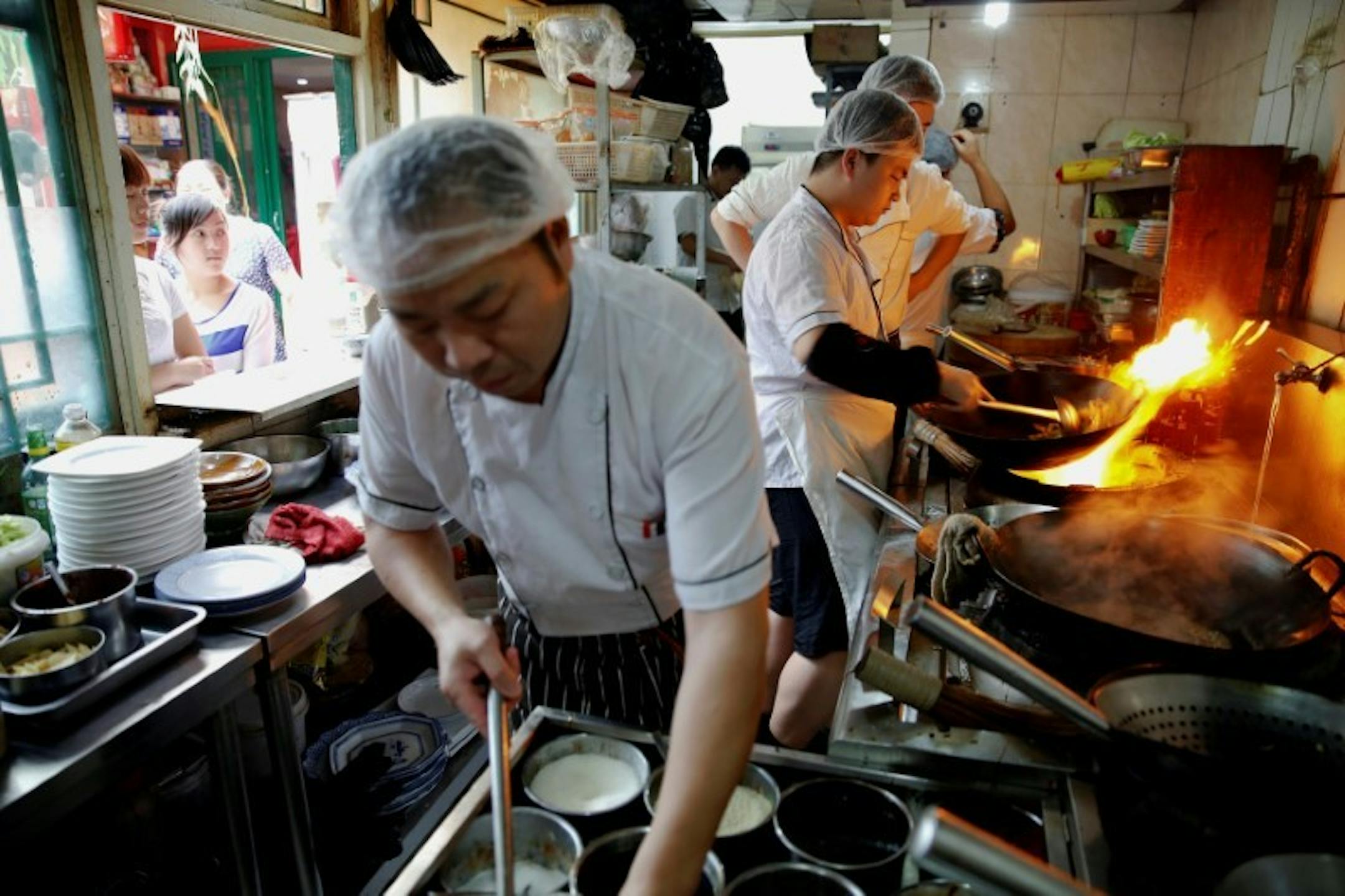 FILE PHOTO: Staff of the Zhenxiangfudi restaurant work in the kitchen, in central Beijing, China May 18, 2016. REUTERS/Damir Sagolj/File Photo