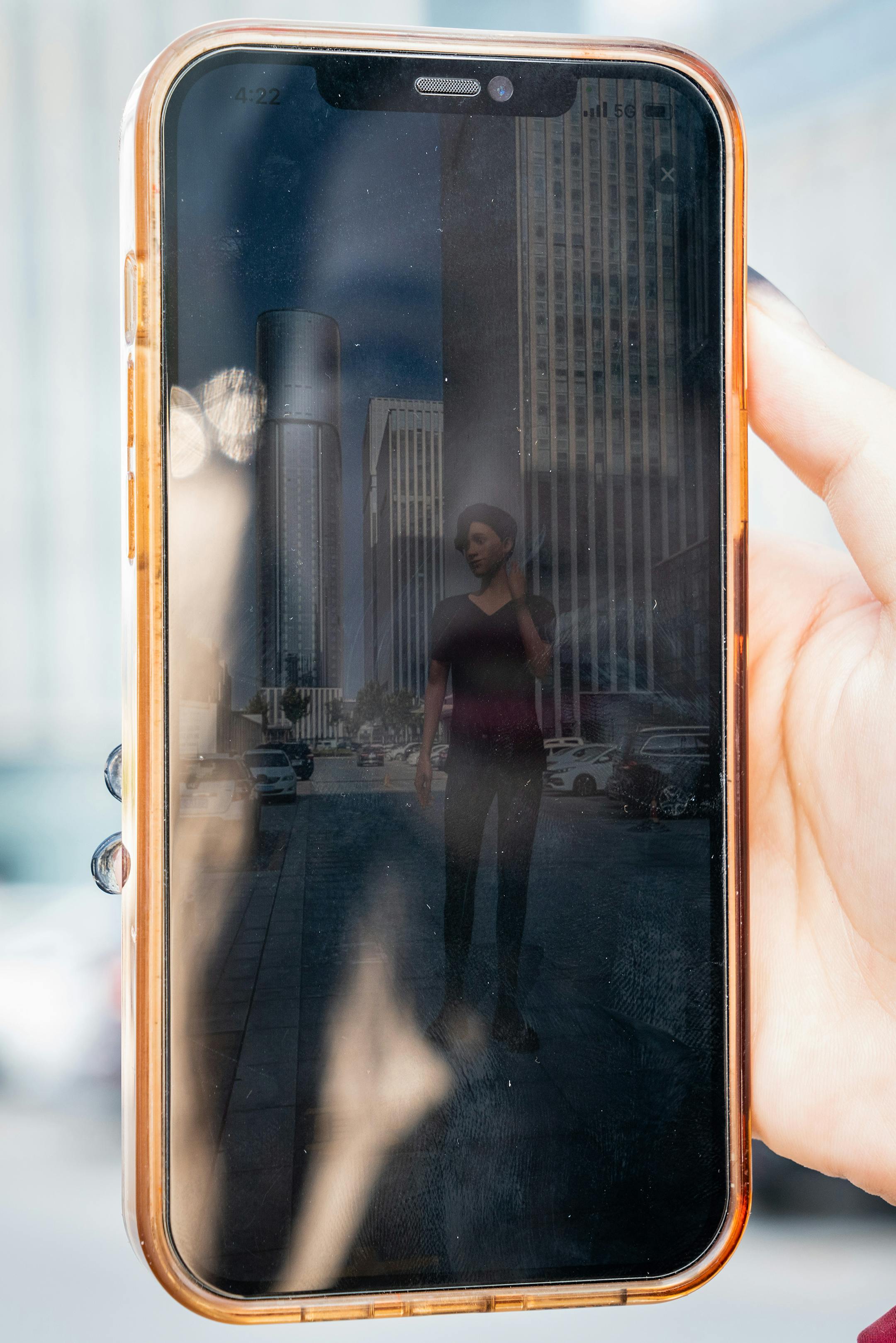 Milly Zhang, an art student, is reflected on her phone's screen as she interacts with her AI boyfriend, Qimat. MUST CREDIT: Photo by Yan Cong for The Washington Post.
