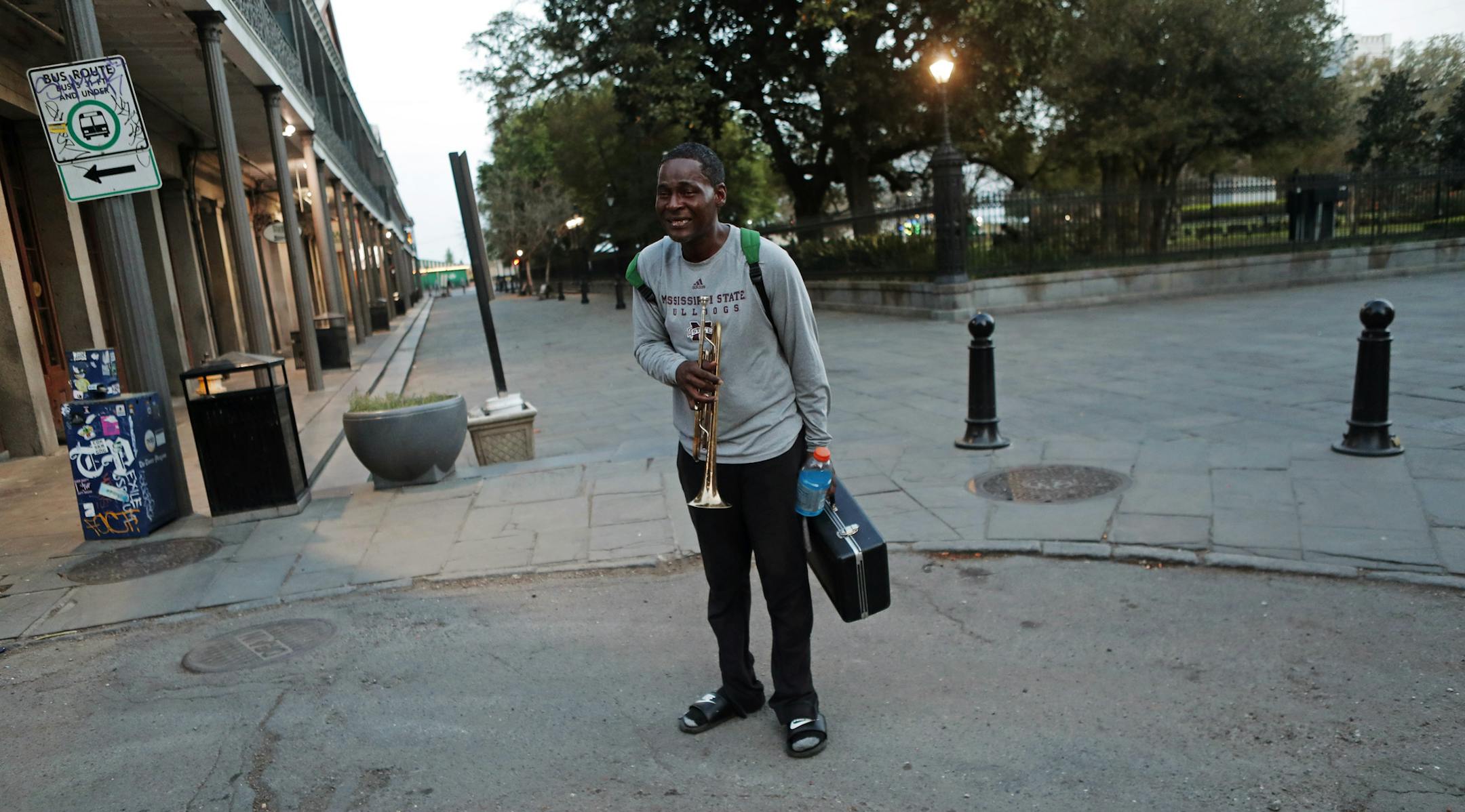 A street musician asks to play music for money in the nearly deserted French Quarter in New Orleans, Sunday, March 22, 2020. With much of the city already hunkered down due to the coronavirus pandemic, Louisiana Gov. John Bel Edwards issues a shelter-in-place order to take effect starting Monday at 5:00 PM. (AP Photo/Gerald Herbert)