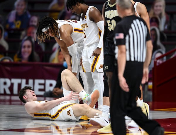 Minnesota Gophers center Liam Robbins (0) grabbed his lower left leg after a hard fall in the second half. ] AARON LAVINSKY • aaron.lavinsky@startri
