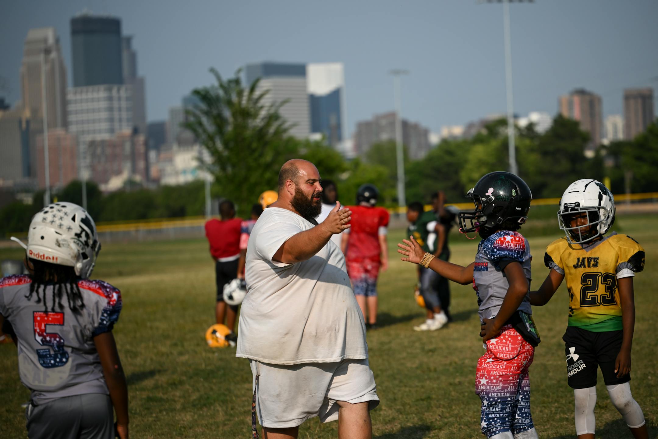 Minnesota Jays coach Adel Morey high-fives one of his players at Bryn Mawr Meadows Park in Minneapolis.