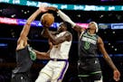 Lakers forward Taurean Prince, center, is defended by Timberwolves center Rudy Gobert (27) and forward Jaden McDaniels in an April game in Los Angeles