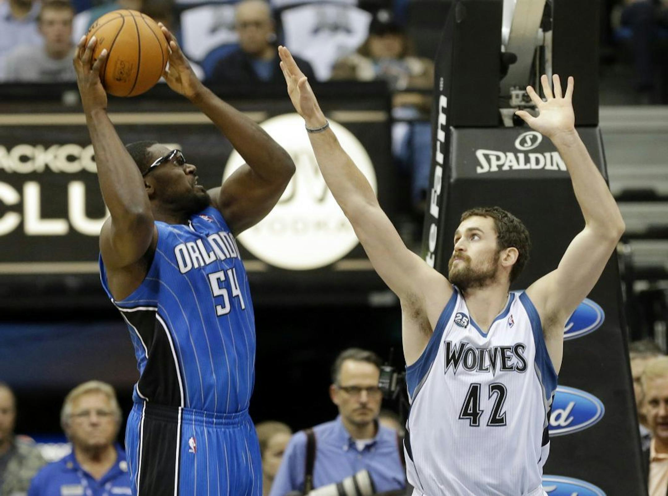Orlando Magic's Jason Maxiell (54) prepares to shoot as Minnesota Timberwolves' Kevin Love, right, defends.