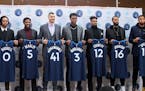 Timberwolves President of NBA Basketball Operations Gersson Rosas, left, and head coach Ryan Saunders, right, pose with new players during an NBA bask