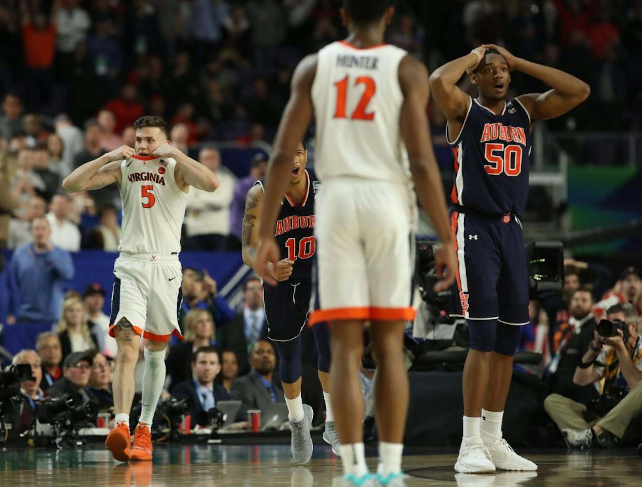 Virginia Cavaliers guard Kyle Guy (5) reacted after being fouled by Auburn guard Samir Doughty (10) on a three point basket near the end of the game against Auburn. Auburn center Austin Wiley (50) reacted at right.