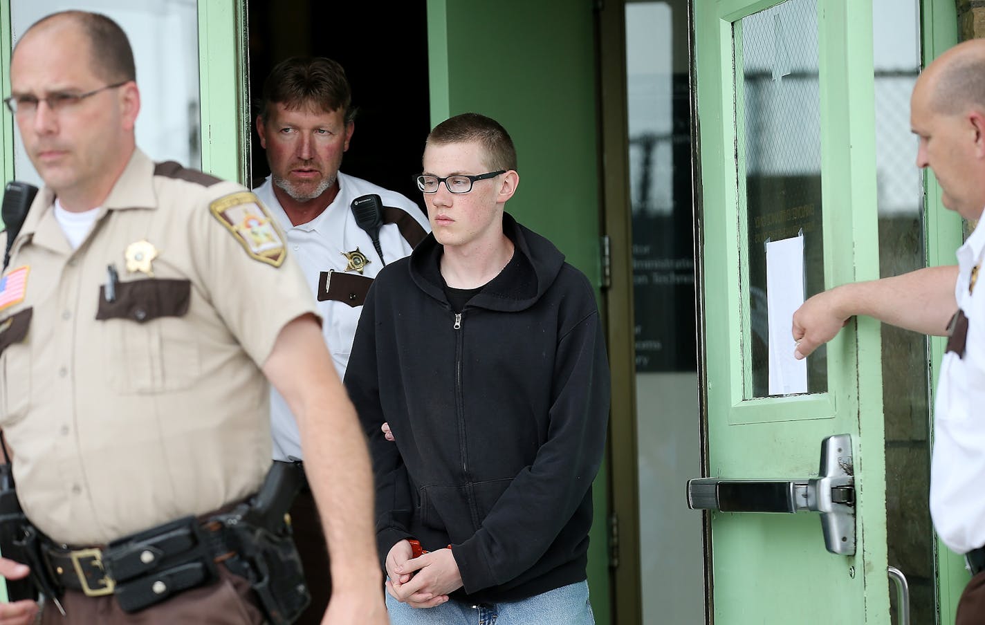 John LaDue was escorted out of the Waseca County Courthouse after he made an appearance for a hearing on whether he should be certified as an adult on June 30, 2015, in Waseca, Minn.