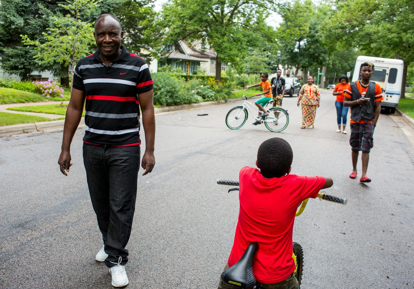 Ladislas Mihigo (left) looks ahead during a family walk around the block near their St. Paul home, on Sunday afternoon. ] COURTNEY PEDROZA &#x2022; courtney.pedroza@startribune.com; Bethel Christian Fellowship Church is hosting its weekly Sunday worship for African refugees; Aug. 13, 2017; Congolese refugees; St. Paul