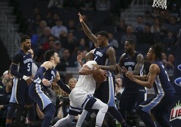 Taj Gibson of the Timberwolves was surrounded by Memphis defenders on Monday night at Target Center.
