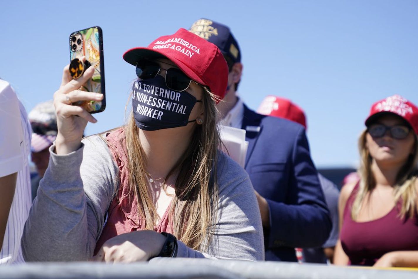 Supporters watch as President Donald Trump speaks to a crowd at the Minneapolis-Saint Paul International Airport, Monday, Aug. 17, 2020, in Minneapolis.