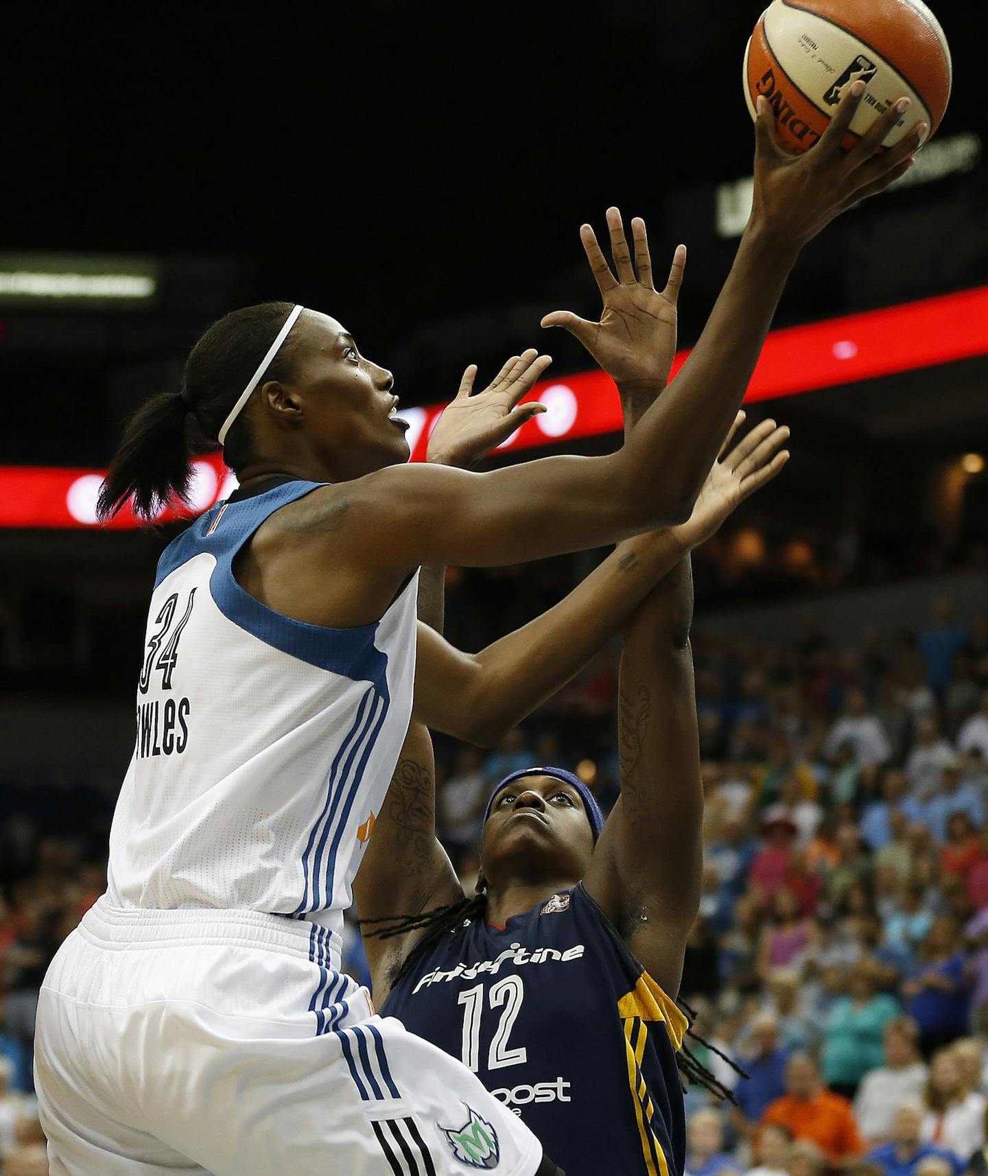 Minnesota Lynx center Sylvia Fowles (34) goes up to the basket past Indiana Fever forwards Tamika Catchings (24) and Lynetta Kizer (12) during the first half of a WNBA basketball game, Friday, Sept. 4, 2015, in Minneapolis. (AP Photo/Stacy Bengs)