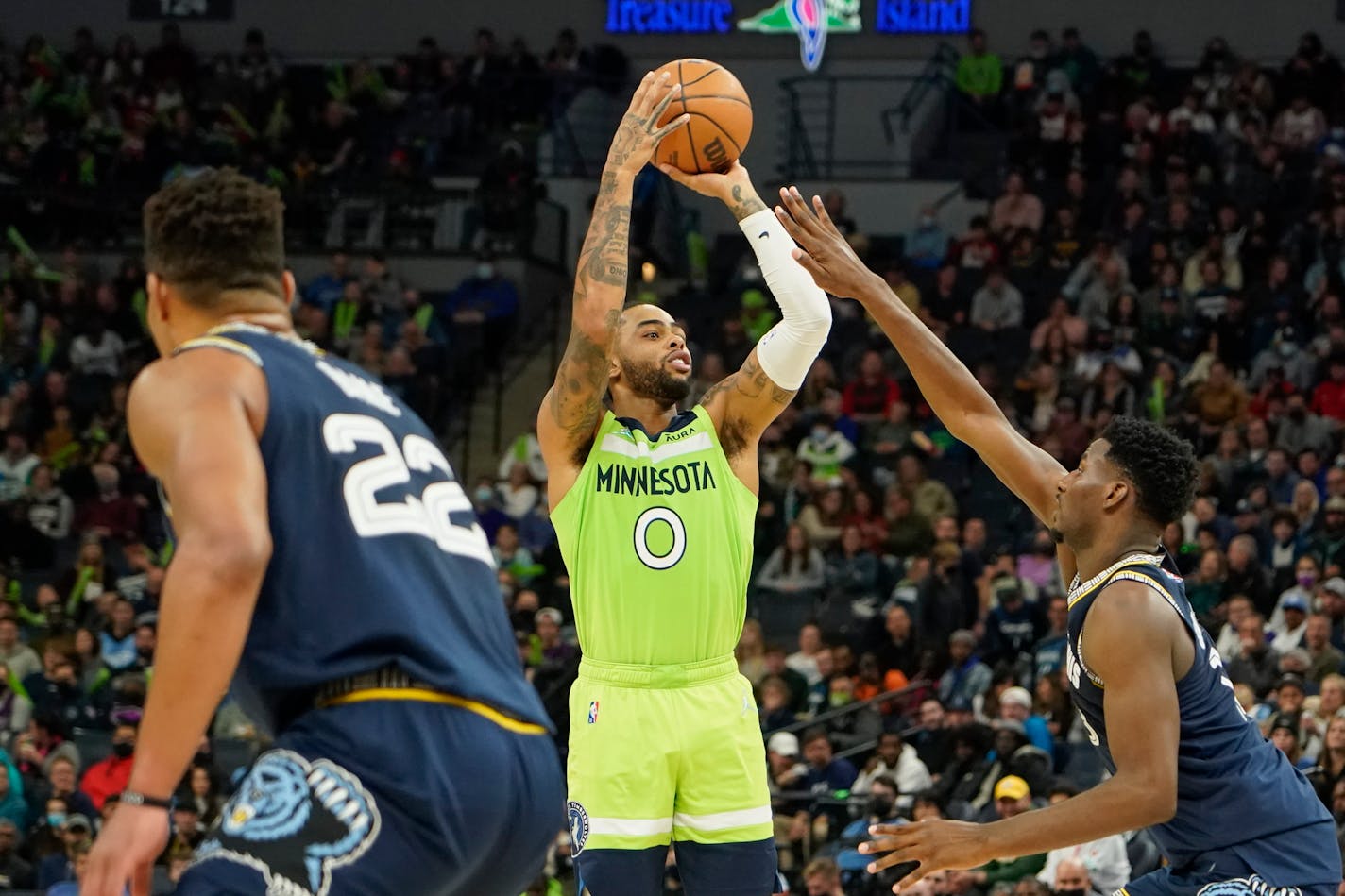 Minnesota Timberwolves guard D'Angelo Russell, center, takes a shot over Memphis Grizzlies forward Jaren Jackson Jr. as forward Desmond Bane looks on during the second half of an NBA basketball game Saturday, Nov. 20, 2021, in Minneapolis. The Timberwolves won 138-95. (AP Photo/Craig Lassig)