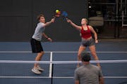 Noah Wolfe and Cora Stallcup both went for a return while taking part in a pickleball league game at the Minneapolis Cider Co. The Minneapolis Cider C