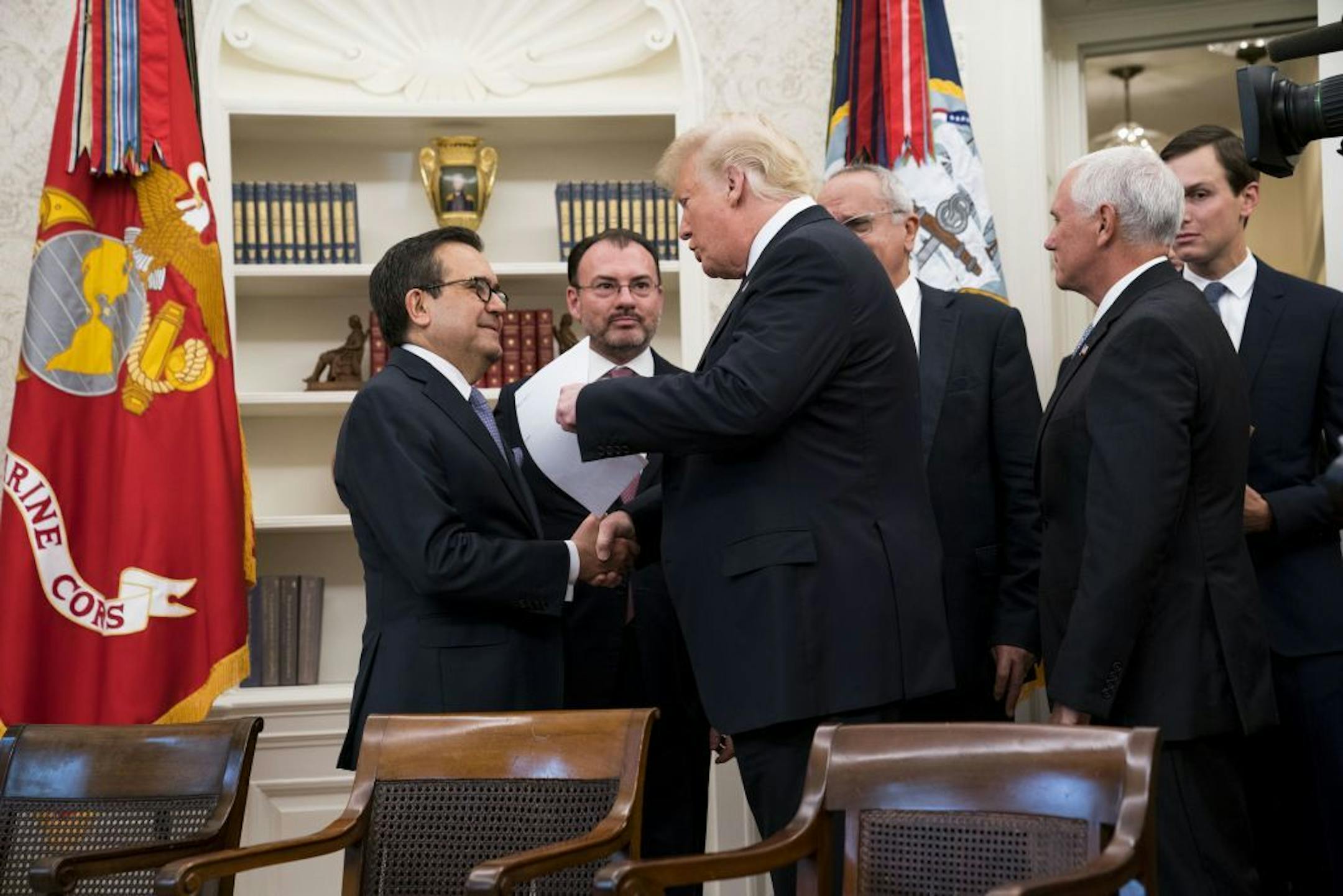 President Donald Trump speaks with Mexico's Economy Minster Ildefonso Guajardo, left, and Foreign Minister Luis Videgaray, second from left, before calling Mexican President Enrique Peña Nieto after the announcement that the U.S. and Mexico have reached an agreement to revise the North American Free Trade Agreement, in the Oval Office of the White House, in Washington, Aug. 27, 2018.
