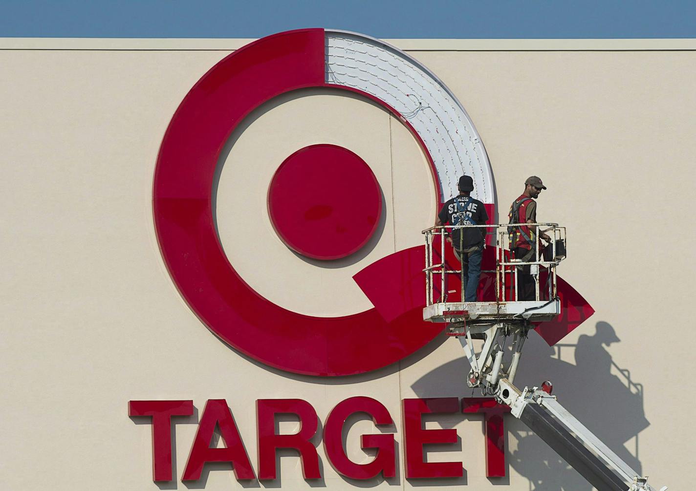 In this July 20, 2013 photo, workers install an outdoor sign at the new Target store at the Mic Mac Mall in Dartmouth, Nova Scotia. On Thursday, Jan. 15, 2015, Target said it plans to exit Canada, citing the company didn't foresee operations being profitable there until at least 2021. (AP Photo/The Canadian Press, Andrew Vaughan)