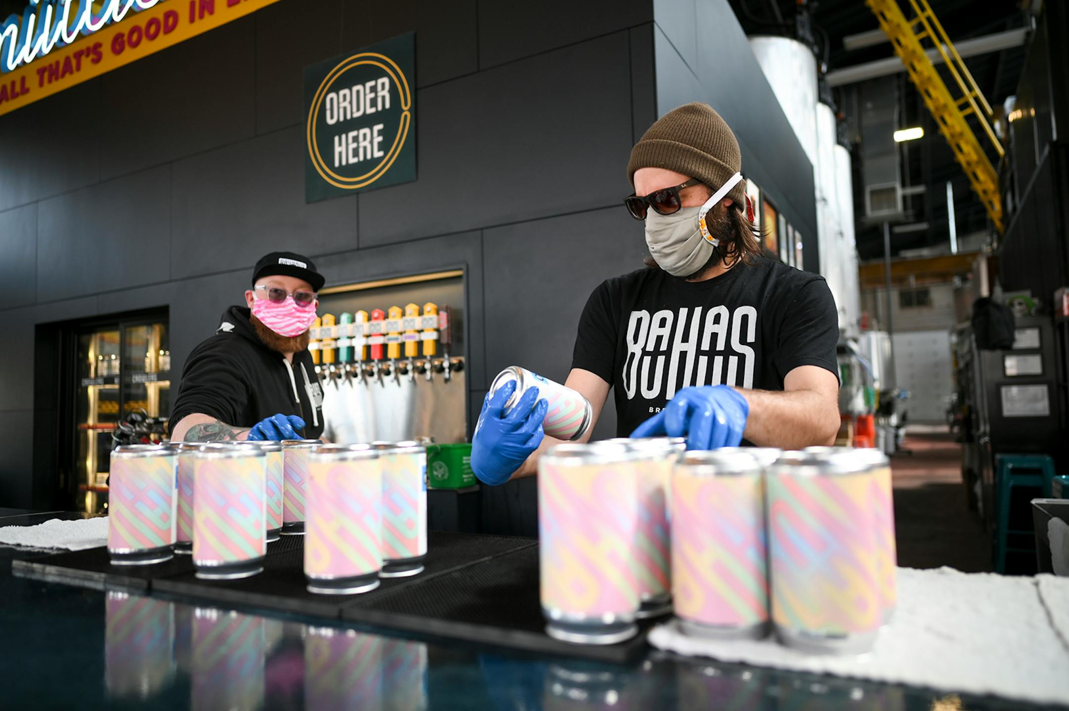 Dan Larsen, right, a brewer at Bauhaus, and Mark Schwandt, co-owner, worked on fulfilling online crowler orders Friday afternoon. Despite strong sales of wine, spirits and beer in liquor stores since COVID-19 hit, craft breweries in Minnesota and other states have taken a body blow, especially the smaller breweries that produce less than 1,000 barrels annually.