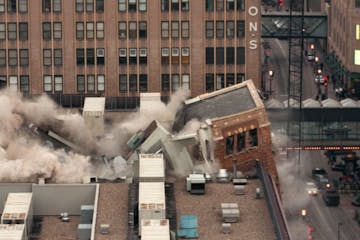 MNP102--A section of the Conservatory buckles after construction crews imploded the building early Sunday morning in the 800 block of Nicollet Ave. in