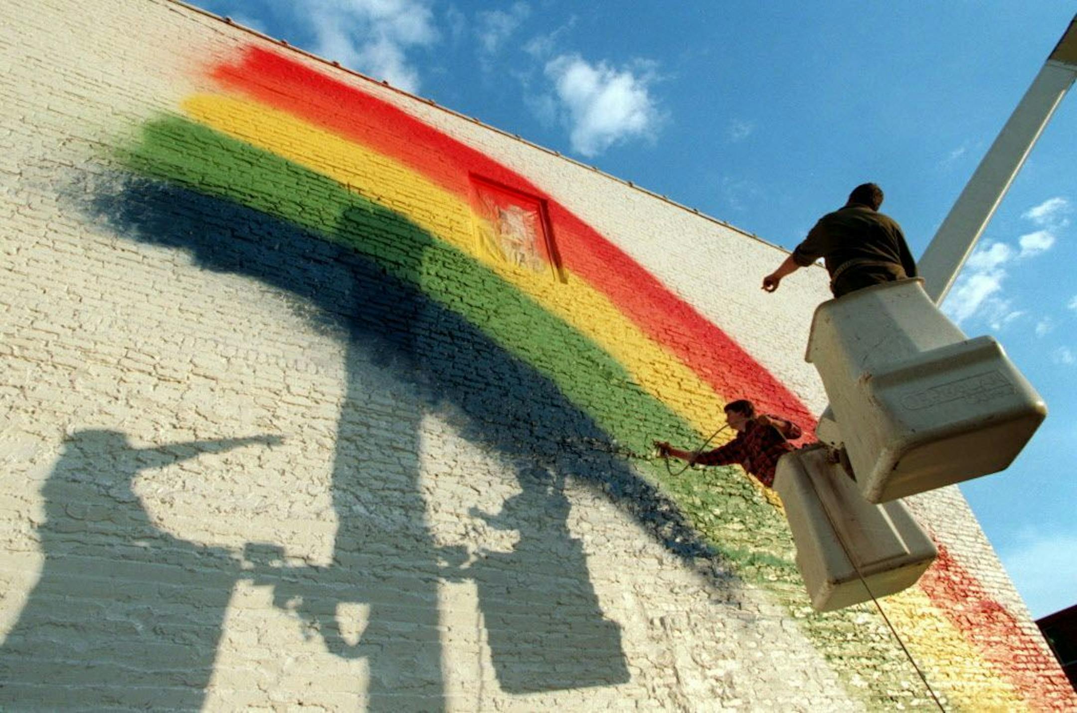 FEATURE ART RAINBOW -- Artist Jason Prigge of Minneapolis gives instructions to painter Daryn Warriner of Minneapolis, Wednesday, as the two work on a new rainbow mural on the side of The Childrens Gospel Mission and Love Power Church on Washington Avenue in Minneapolis.