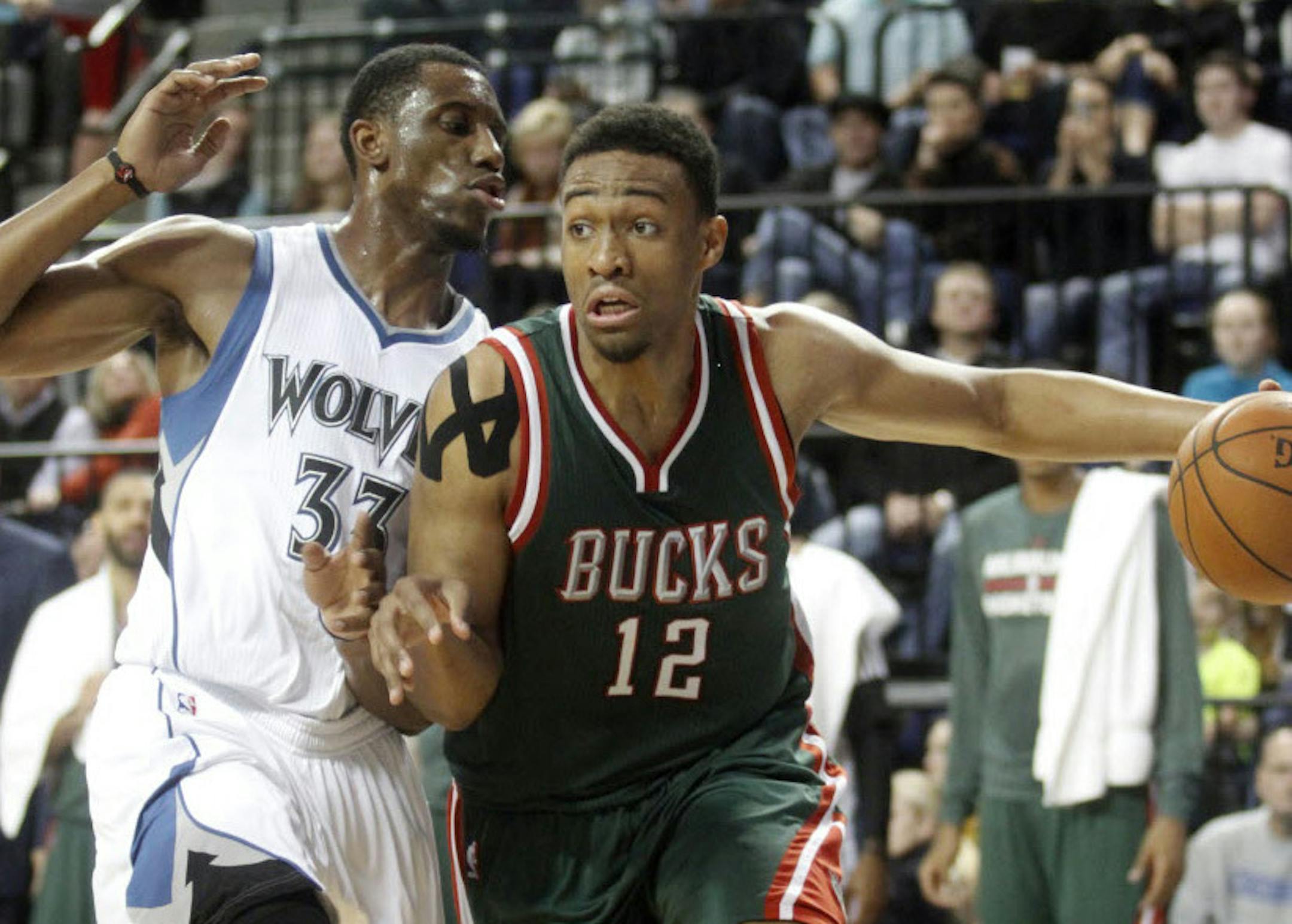 Milwaukee Bucks forward Jabari Parker, right, drives to the basket past Minnesota Timberwolves forward Andrew Wiggins during the first half of a preseason NBA basketball game Friday in Cedar Rapids, Iowa.