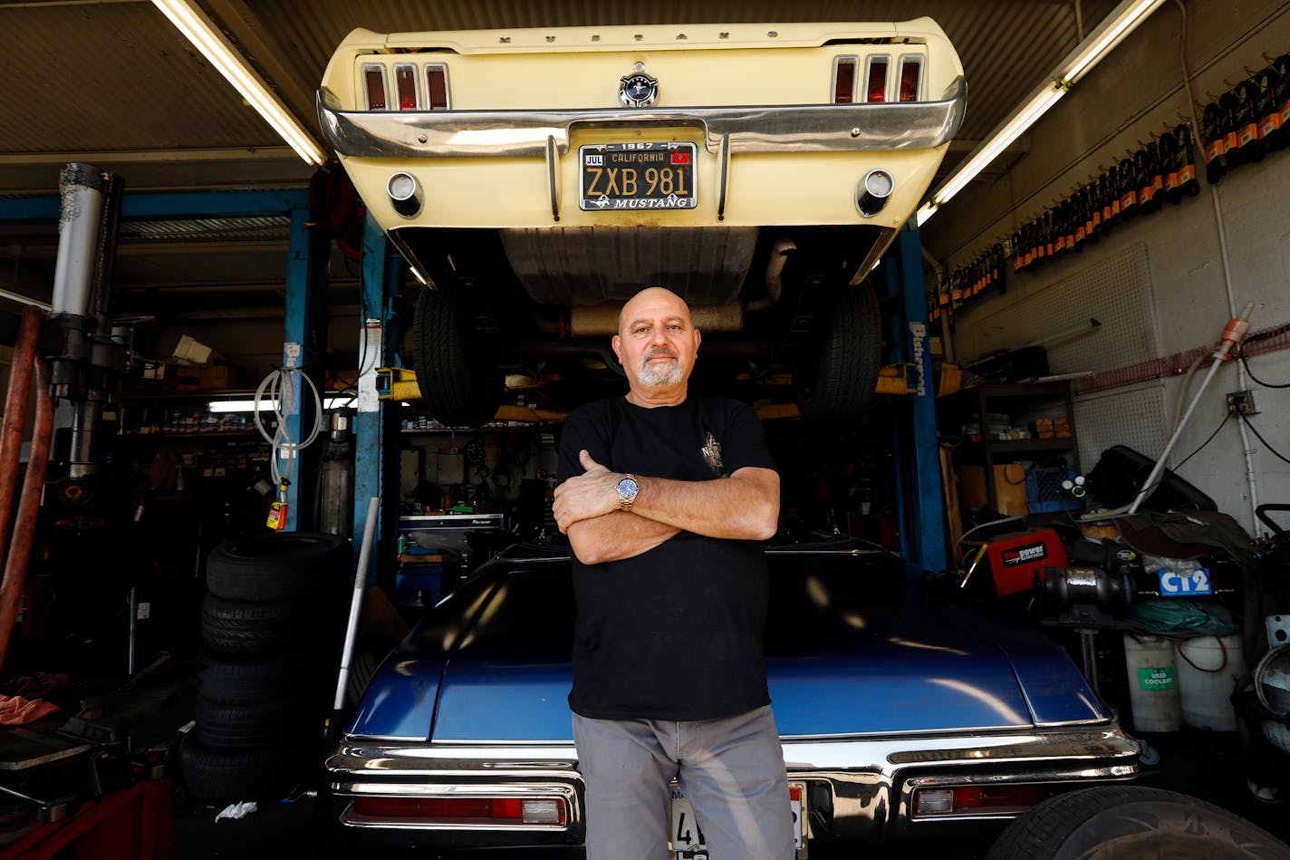 Hagop Berberian, owner of Allright Automotive in Inglewood, gives his mechanics bonuses when a month's business is good, helping them meet surging living costs. Above, he poses with his personal Mustang. (Carolyn Cole/Los Angeles Times/TNS)