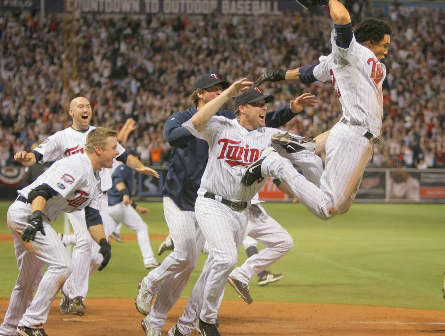 Twins celebrate as Gomez scores winning run.