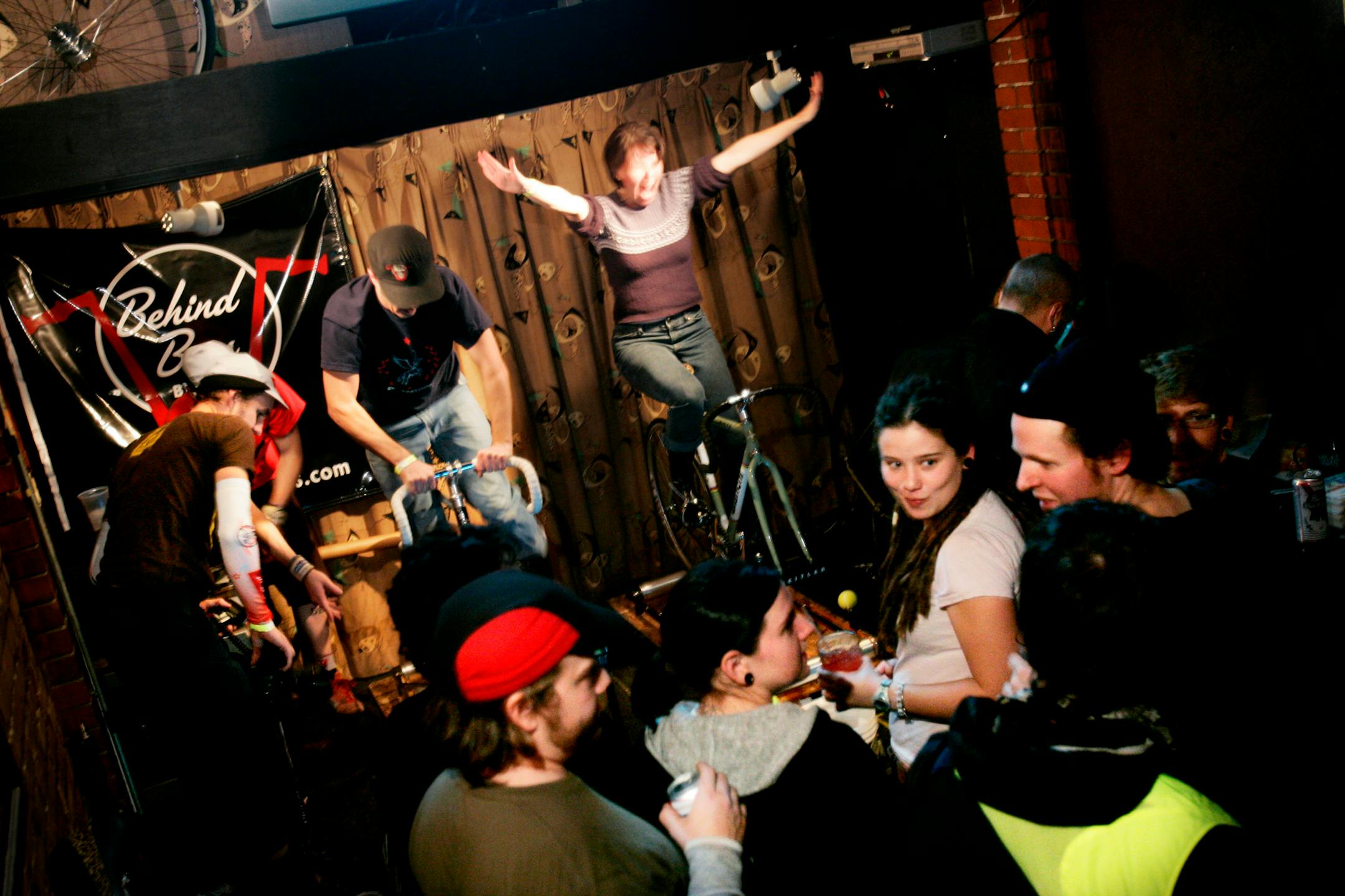 Crowds gathered to socialize and cheer on goldsprint racers, including Martha Flynn (arms in air), during an event at Grumpy's Bar & Grill in Minneapolis