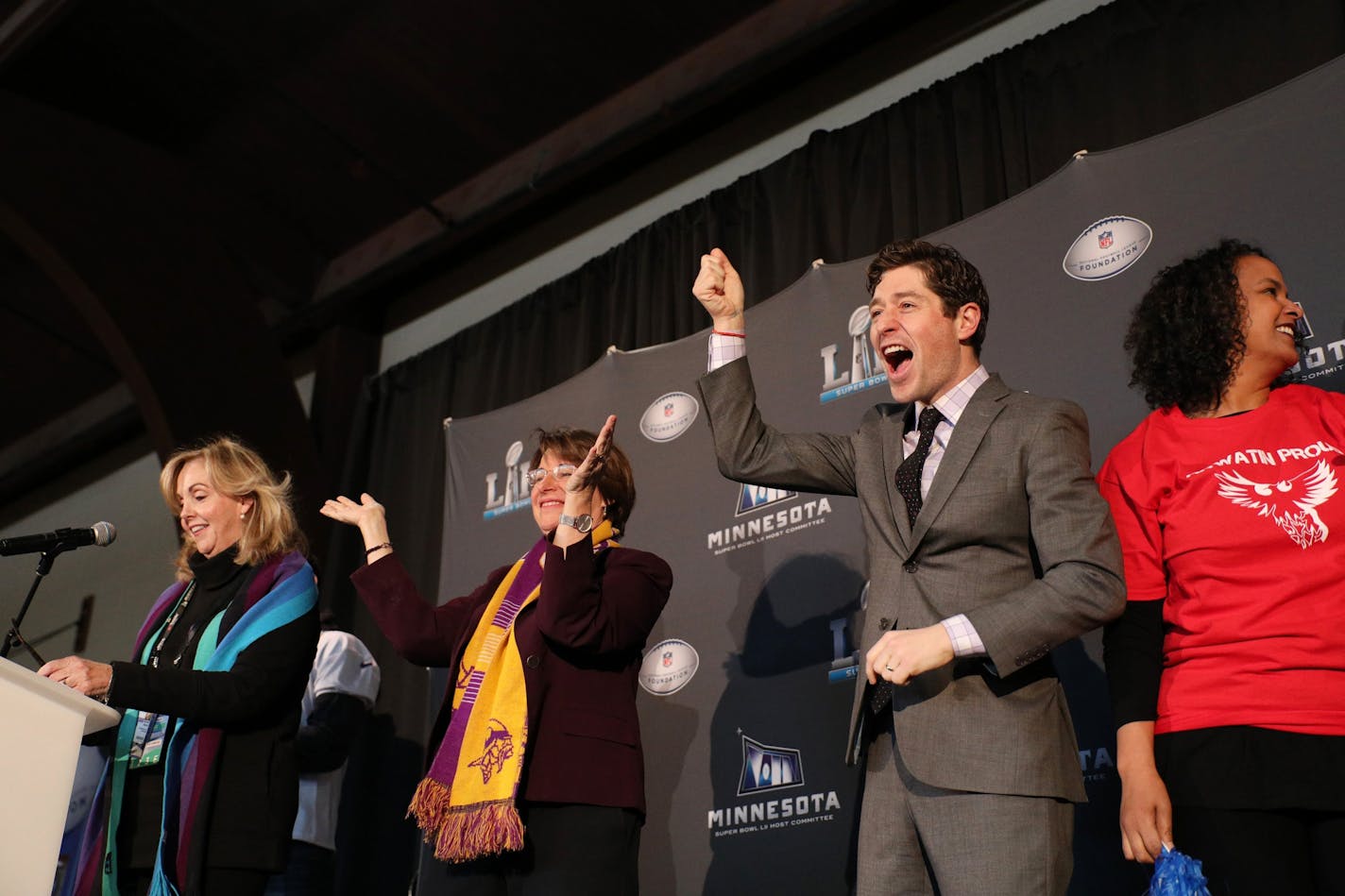 Minneapolis Mayor Jacob Frey cheered as he took the stage along with others including Sen. Amy Klobuchar, left, to announce Thursday that Anwatin Middle School in Minneapolis received a $220,000 grant, the final for the 52 Weeks of Giving campaign.