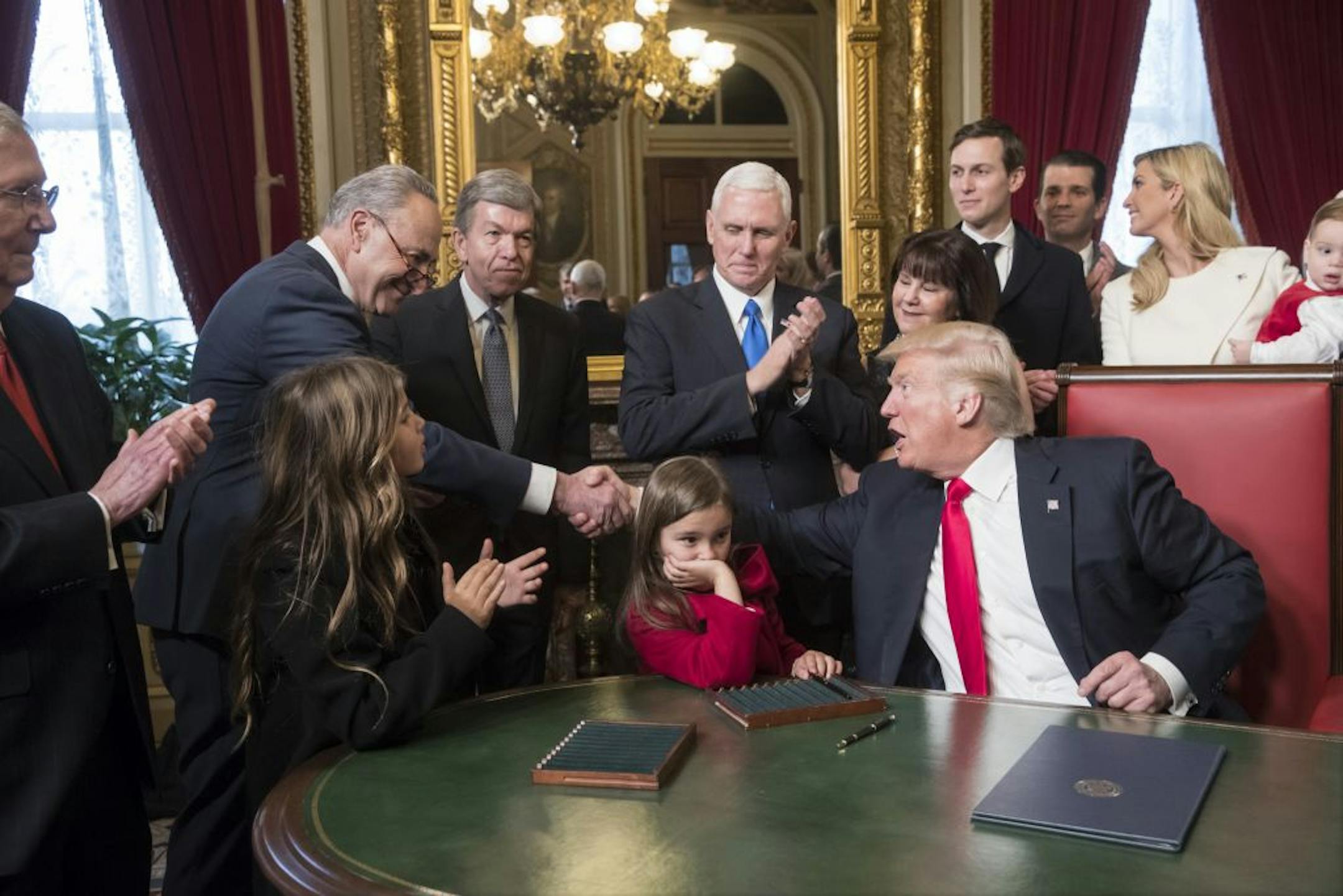 President Donald Trump shakes hands with Senate Minority Leader Charles Schumer of N.Y, as he is joined by the Congressional leadership and his family while he formally signs his cabinet nominations into law, Friday, Jan. 20, 2017, in the President's Room of the Senate on Capitol Hill in Washington. From left are, Senate Majority Leader Mitch McConnell, R-Ky., Senate Minority Leader Chuck Schumer, D-N.Y, Sen. Roy Blunt, R-Mo., Vice President Mike Pence and his wife Karen Pence, Jared Kushner, Do