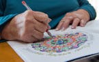Beth Camasar colors an adult coloring book in her New London, Conn. home Thursday, Jan. 7, 2016. Camasar lost feeling in her hands a year ago and is t