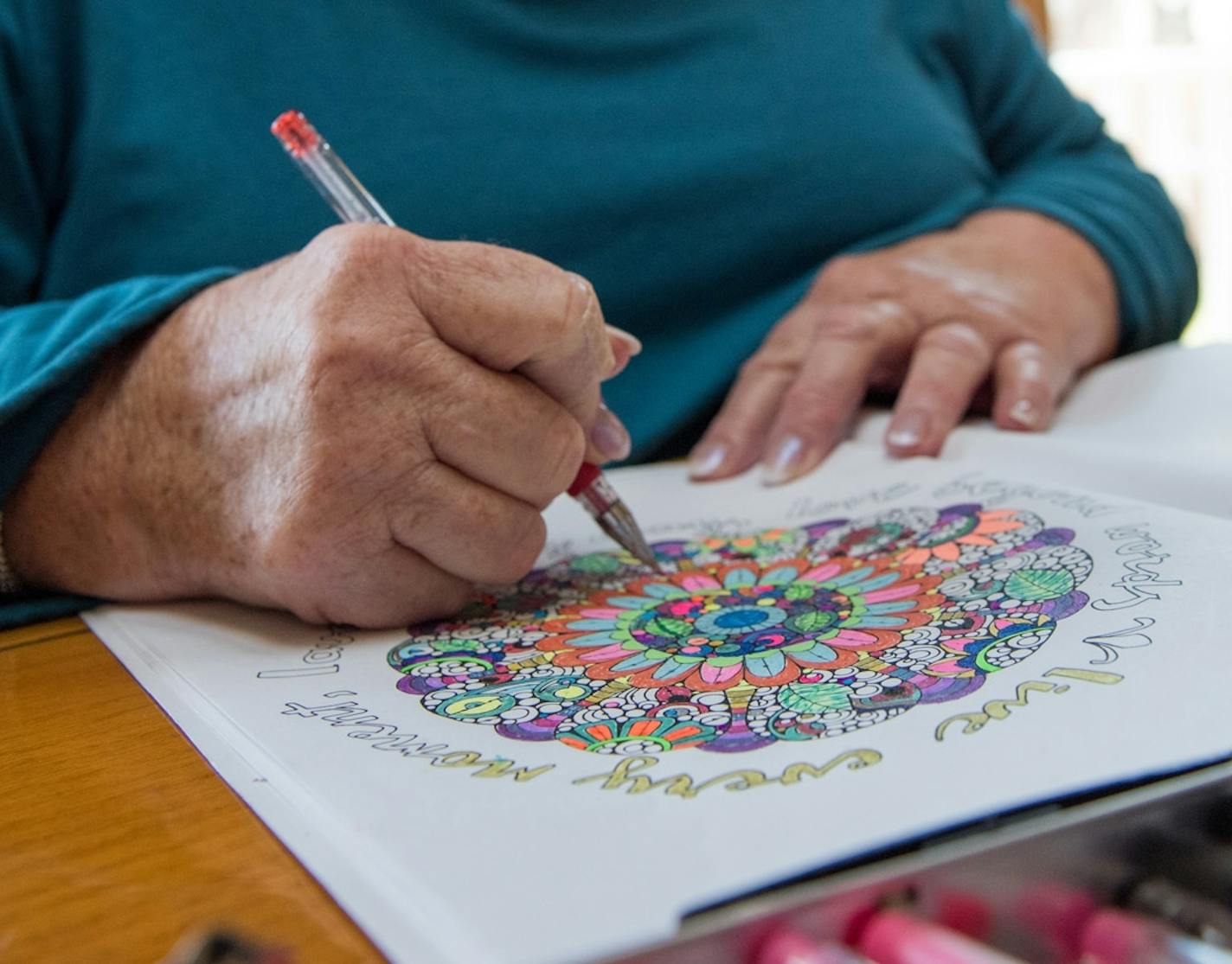 Beth Camasar colors an adult coloring book in her New London, Conn. home Thursday, Jan. 7, 2016. Camasar lost feeling in her hands a year ago and is trying adult coloring as a therapy. (Shelly Yang/The Day via AP) MANDATORY CREDIT (REV-SHARE)