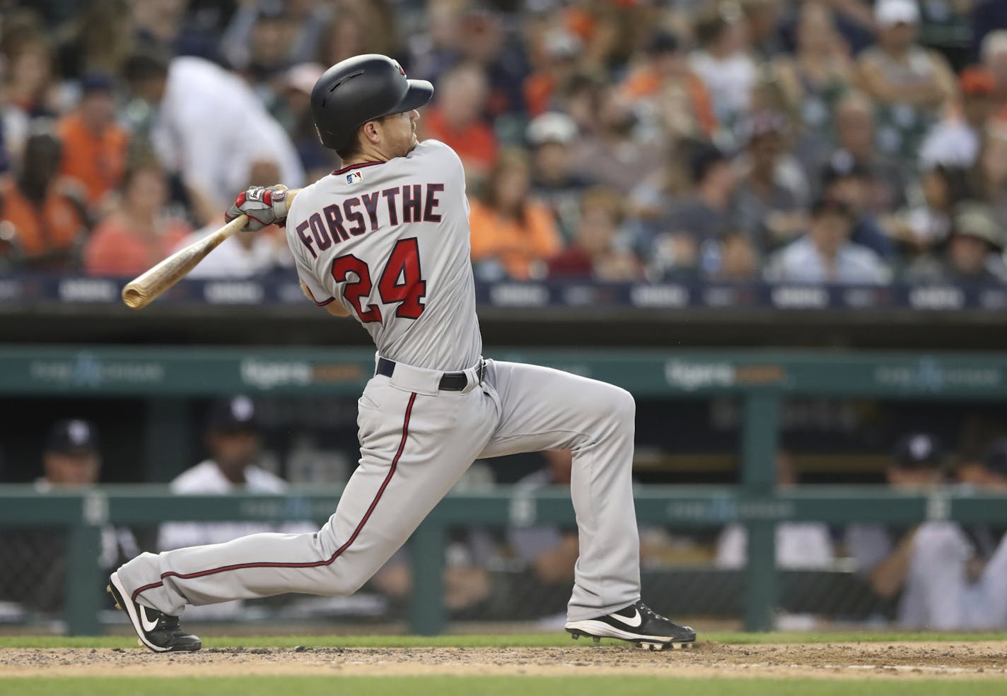 Minnesota Twins second baseman Logan Forsythe hits the ball to Detroit Tigers third baseman Jeimer Candelario who overthrows to the first baseman resulting in a double during the sixth inning of a baseball game, Friday, Aug. 10, 2018, in Detroit.