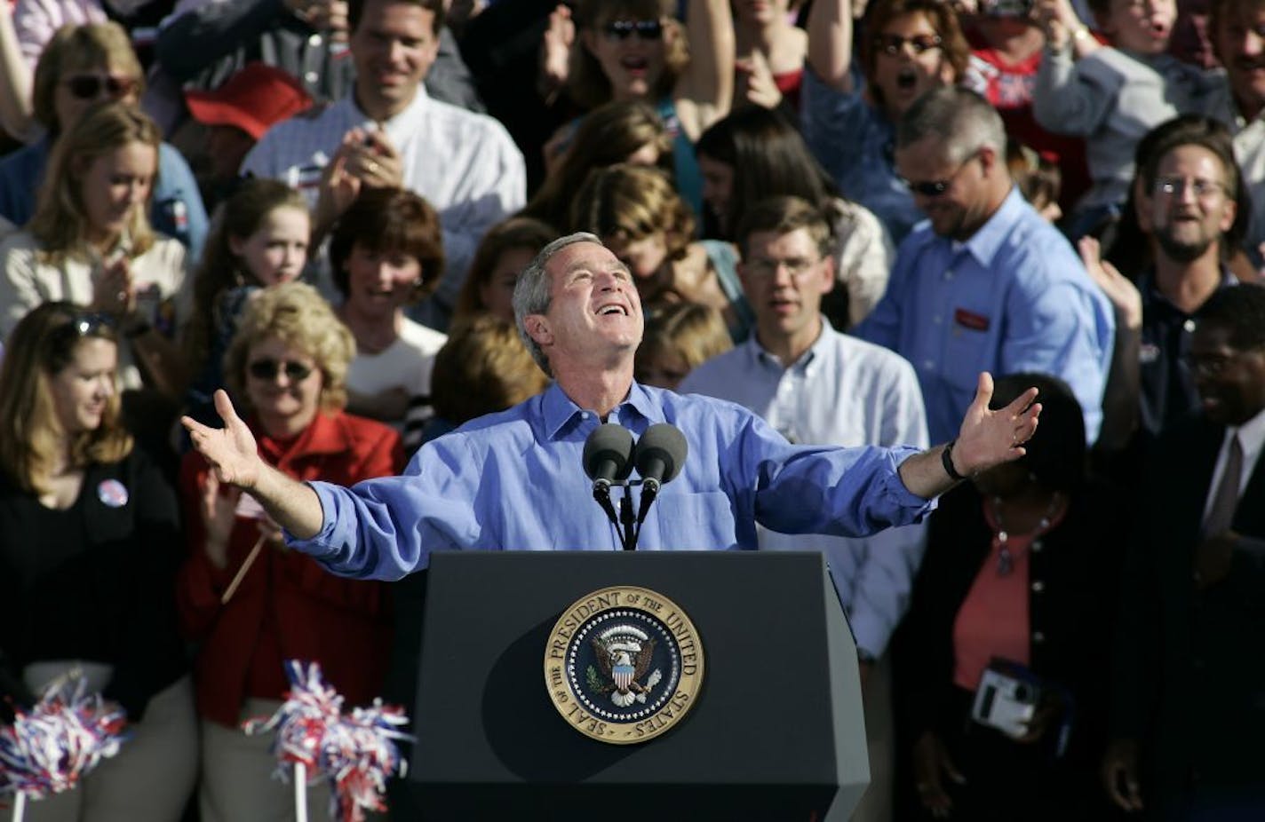 President Bush looks up at the sky as he comments on how good the weather is before beginning his speech before supporters at Chanhassen Elementary School in Chanhassen, Minn., Oct. 9, 2004.