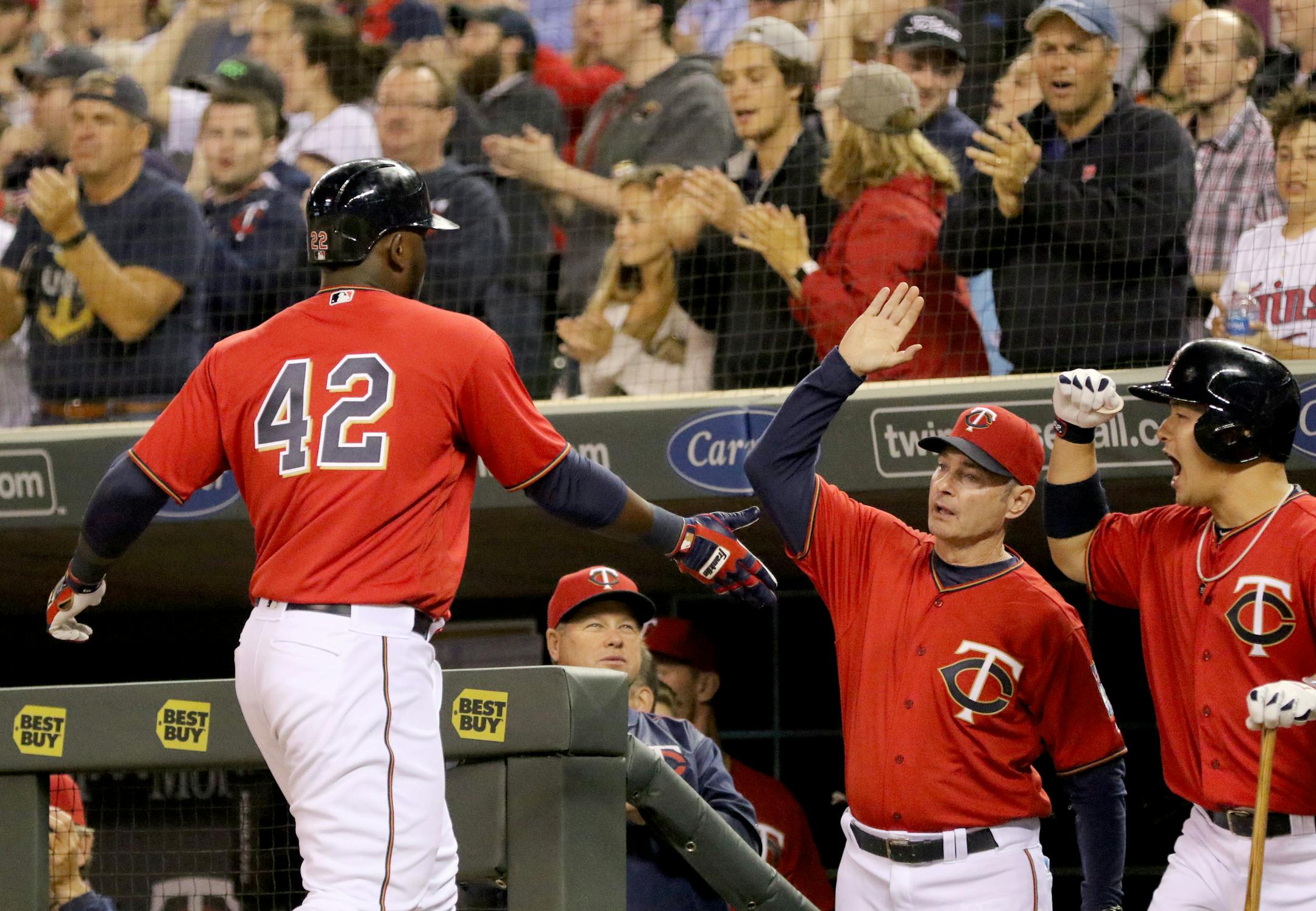 Minnesota Twins right fielder Miguel Sano, left, gets a high five from manager Paul Molitor and Byung Ho Park after scoring from second on a Trevor Plouffe double in the 6th inning