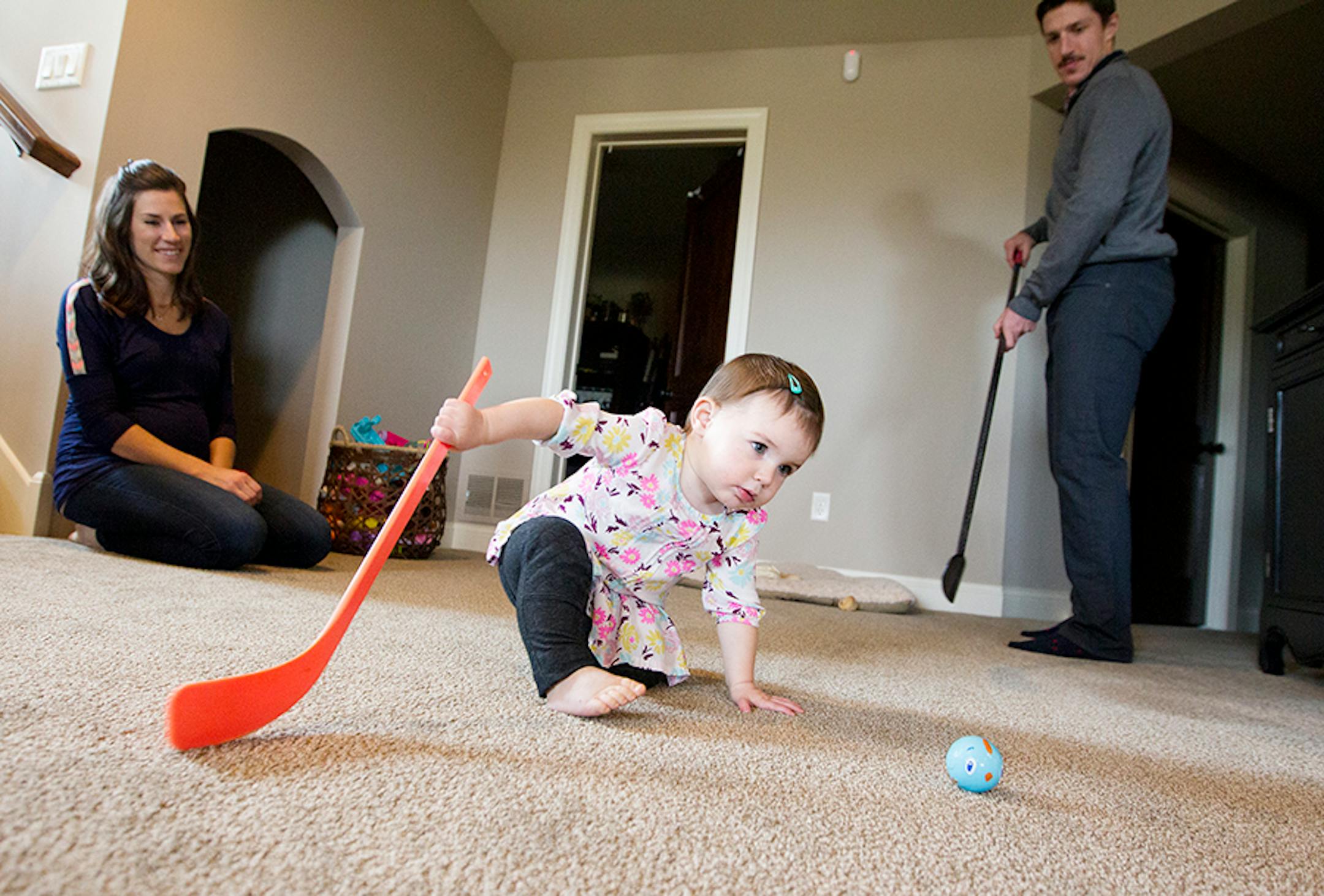 Minnesota Wild's Ryan Carter plays hockey with his daughter Natalie, 15 months, as his wife Erin looks on at their home in Gem Lake November 22, 2015.