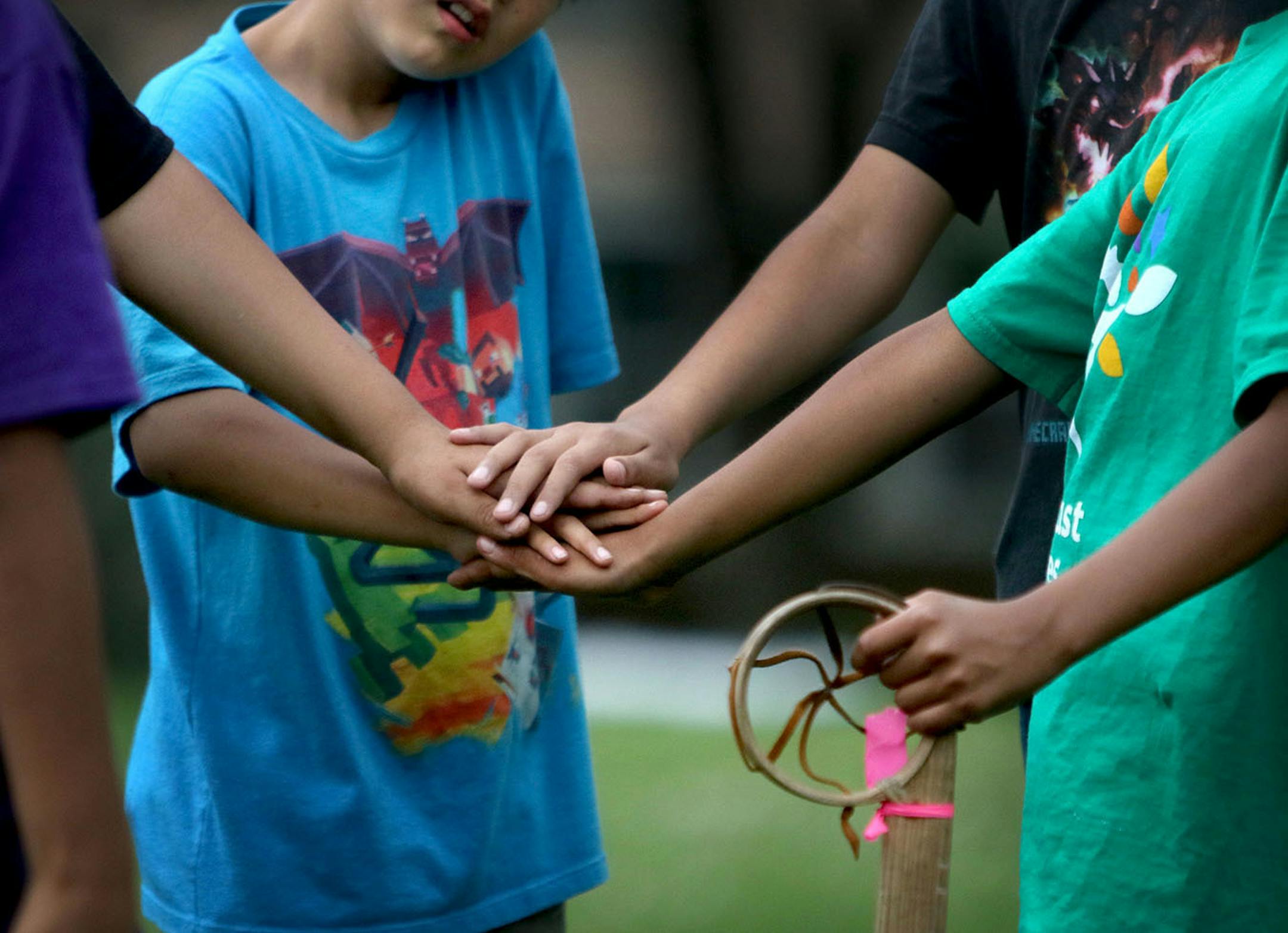 Youth boys team members of Twin Cities Native Lacrosse join hands in a circle during practice at Corcoran Park Wednesday, June 17, 2015, in Minneapolis, MN. The traditional Lacrosse players, who play with hand carved ash sticks, were preparing for the upcoming Twin Cities Native Lacrosse Tournament at the Osseo High School Saturday.