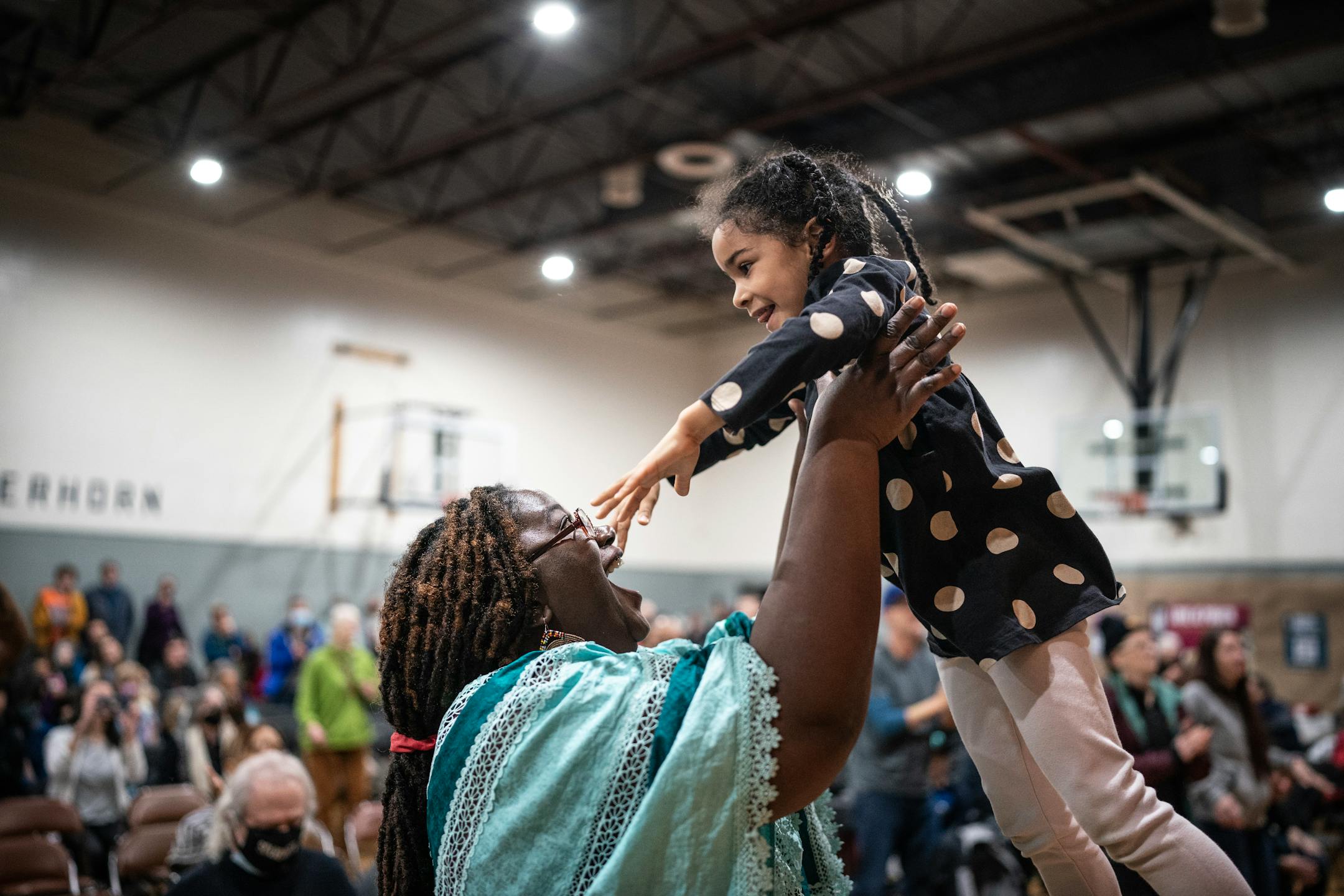 Kashimana Ahua, lifted her daughter Sierra, as they danced to the music of the Brass Solidarity Band during the Martin Luther King Jr. celebration at Powerhorn Park.