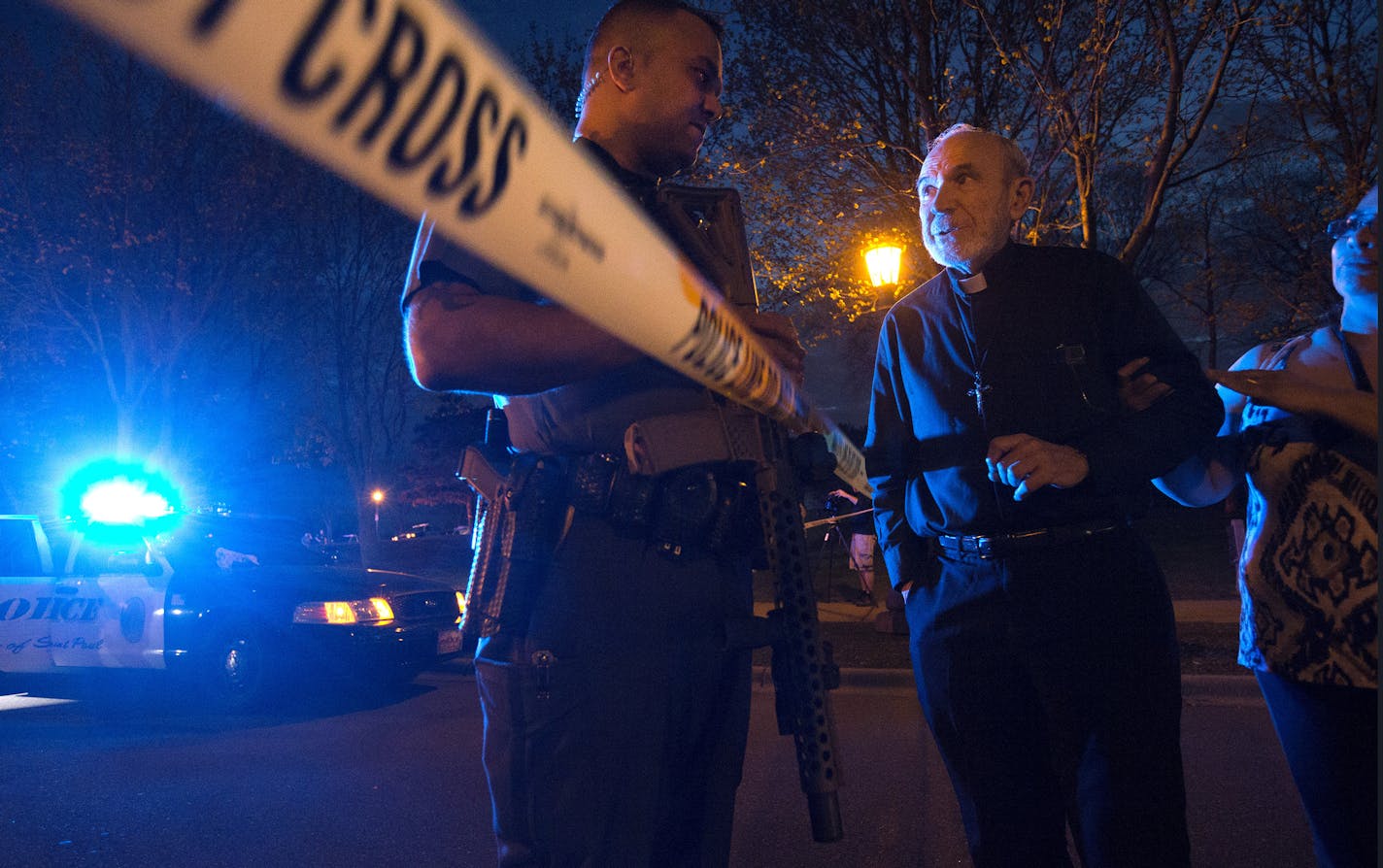 The Rev. Lawrence Hubbard spoke with a St. Paul police officer near the scene of a multiple shooting that took place Sunday night at Indian Mounds Regional Park in St. Paul.