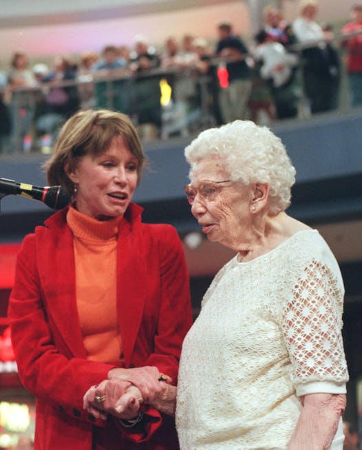 -- With hundreds of fans watching at the Mall of America, Mary Tyler Moore meets Hazel Frederick, the woman who was filmed looking puzzled at Moore while she threw her cap in the air during the opening of The Mary Tyler Moore Show 25 year ago.