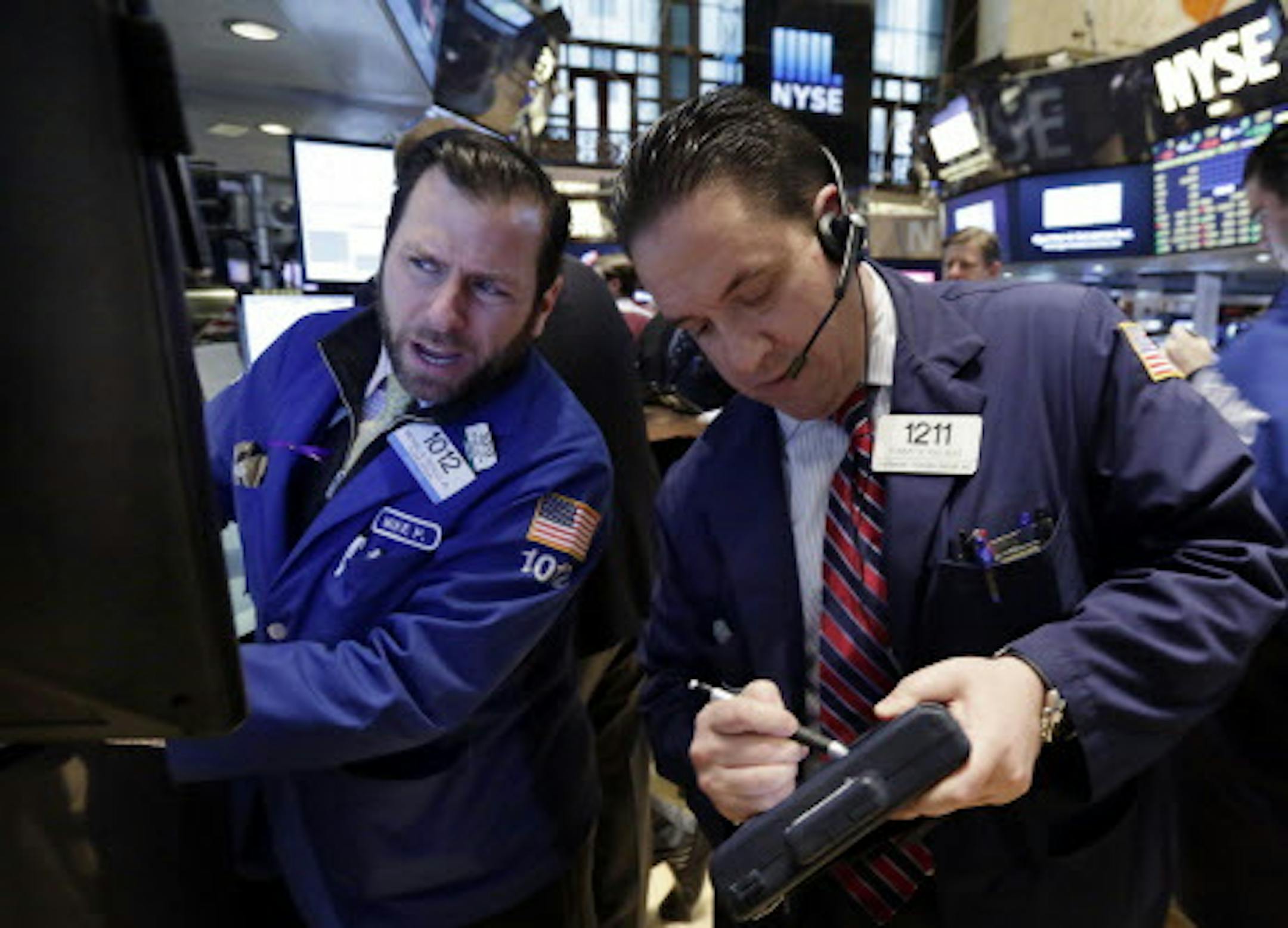 Specialist Michael Pistillo, left, and trader Tommy Kalikas workon the floor of the New York Stock Exchange Monday, Feb. 23, 2015. U.S. stocks are opening slightly lower, pulling the market back from an all-time high reached last week. (AP Photo/Richard Drew)