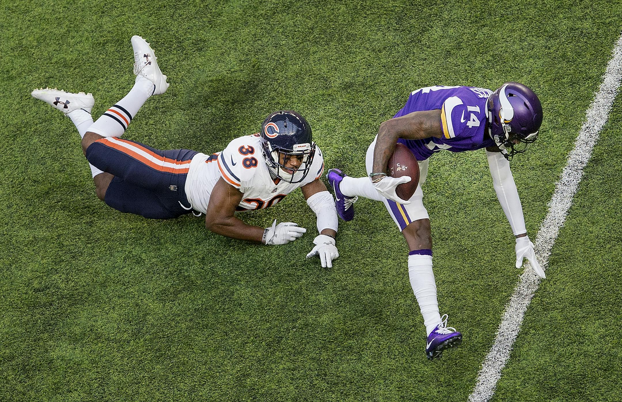 Stefon Diggs (14) broke away from Adrian Amos (38) after catch in the first quarter.