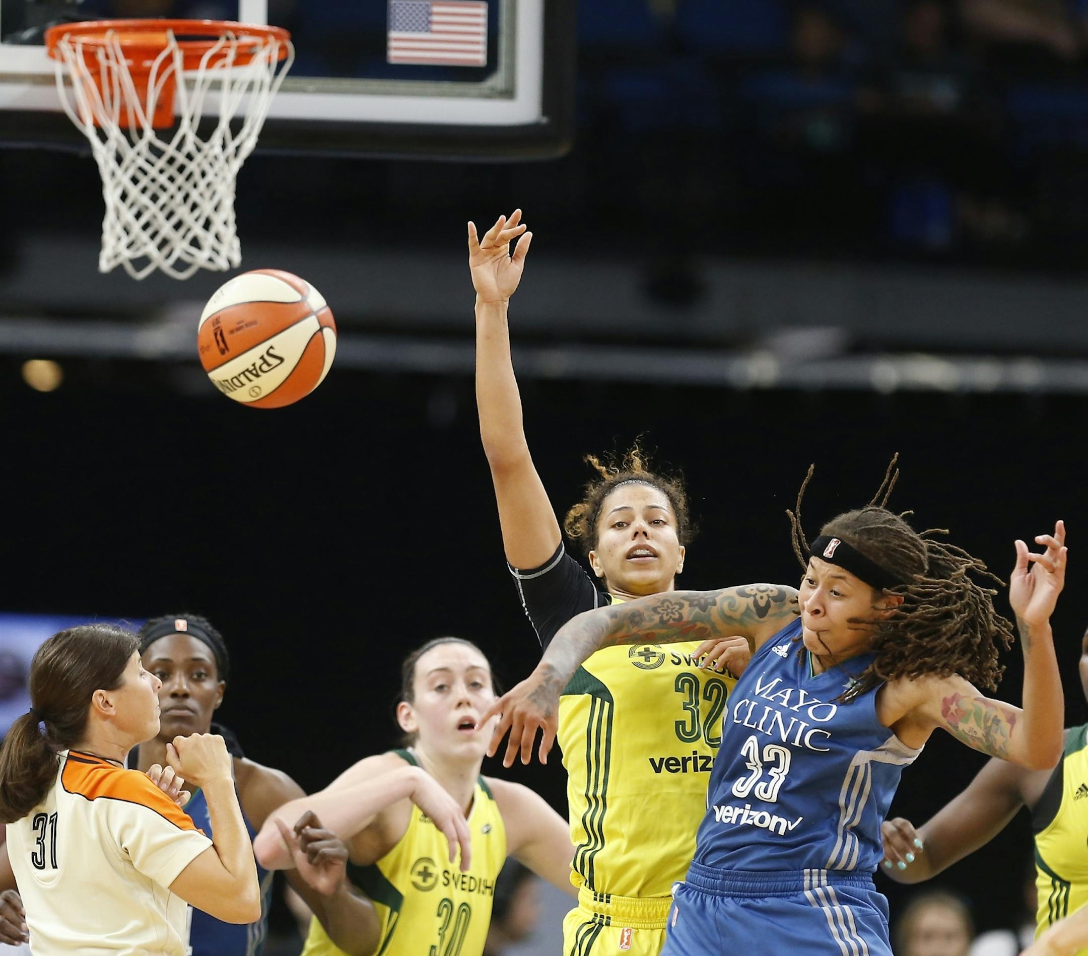 Minnesota Lynx guard Seimone Augustus (33) and Seattle Storm forward Alysha Clark (32) both go for a jump ball during the first half.