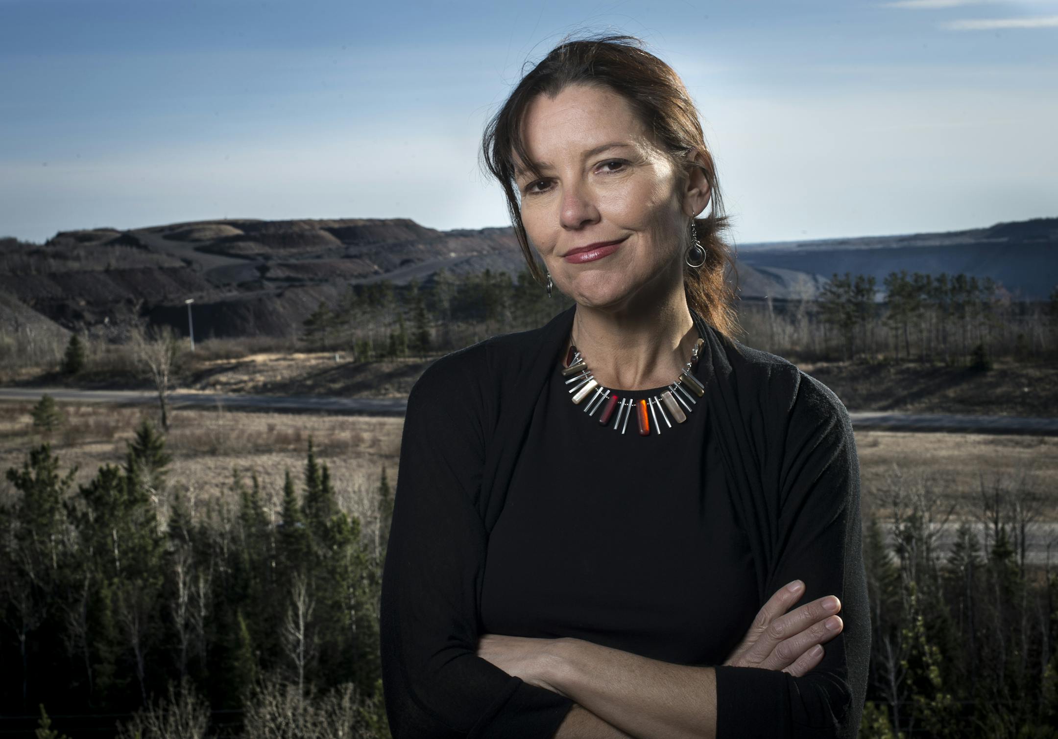 Megan Marsnick, author of the summer book installment series, is photographed from the top of Mineview in the Sky in Virginia, Minn. Behind her is a working iron mine. ] (Aaron Lavinsky | StarTribune) aaron.lavinsky@startribune.com Megan Marsnick, author of the summer book installment series, has written about the early days on the iron range. She was photographed Saturday, April 18, 2015 at Mineview in the Sky in Virginia, Minn.