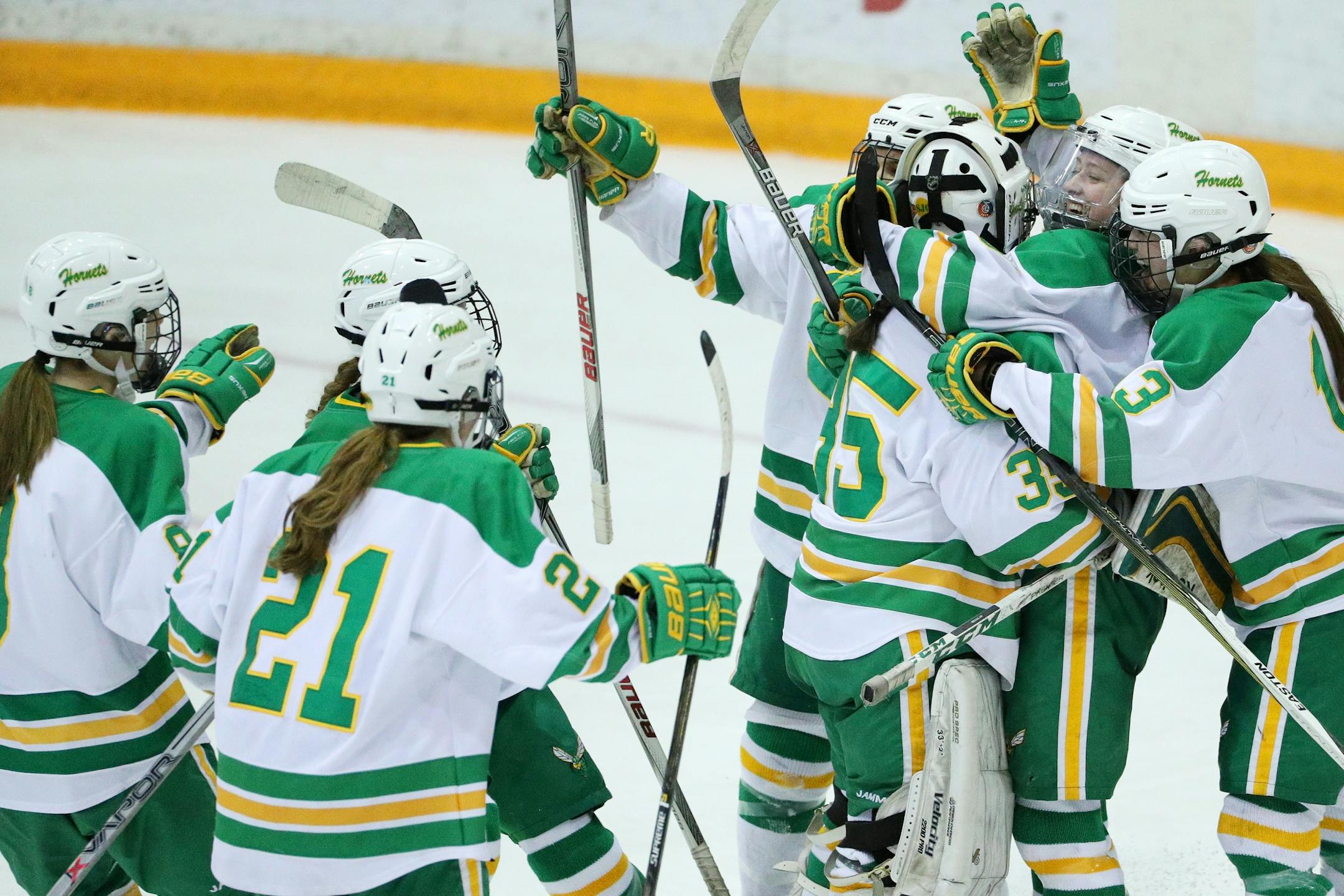Edina players mob goaltender Anna Goldstein after winning the Class 2A, Section 6 championship game against Cretin-Derham Hall.