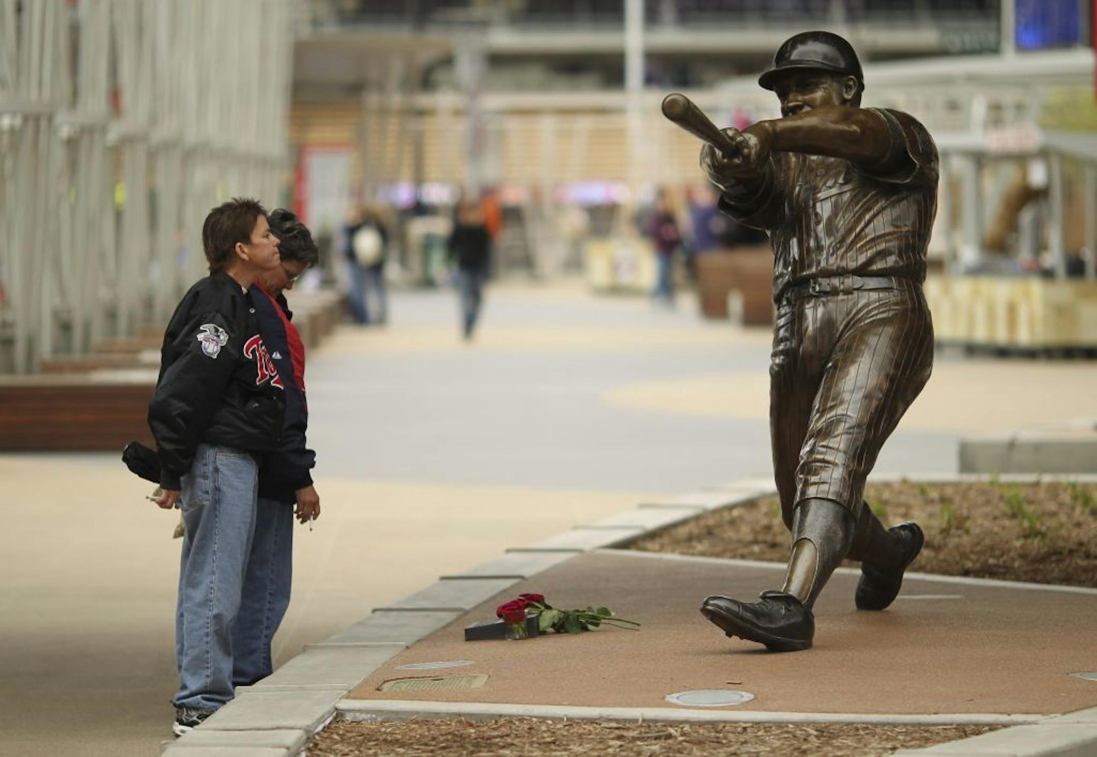 Mary Vaessen, left, and Jackie Anderson paused by the statue of Harmon Killebrew outside Target Field on their way to the game Friday night. "He's a legend, man," said Anderson. "I hate to see that he's going into hospice, but at least he'll be well taken care of," added Vaessen.