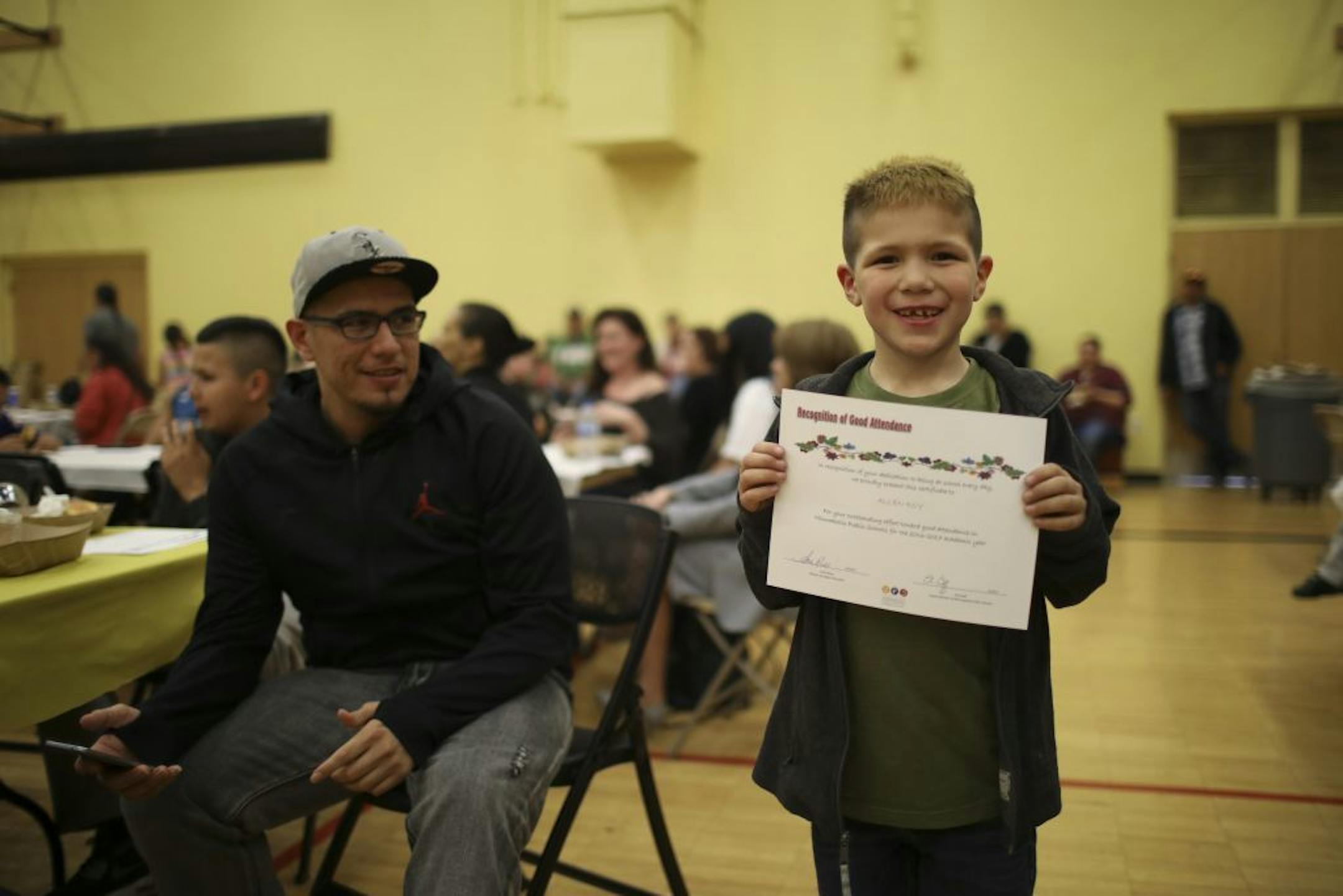 Allen Roy showed off his attendance award. At left was his dad, Lawrence Roy Sr. All of Allen's brothers and his sister also received attendance awards.