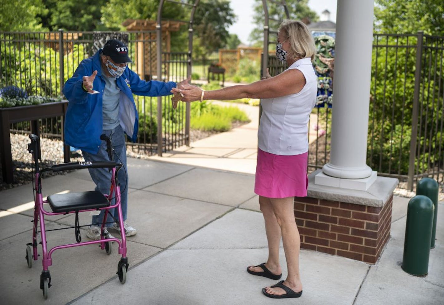 Victoria Conrad opened her arms to do a distant hug with her 99-year old father Howard Seitzer as they met for their first face-to-face visit since the Covid-19 pandemic closed off his senior living home to visitors in March at Oak Meadows Senior Living in Oakdale, Minn., on Thursday, June 18, 2020.