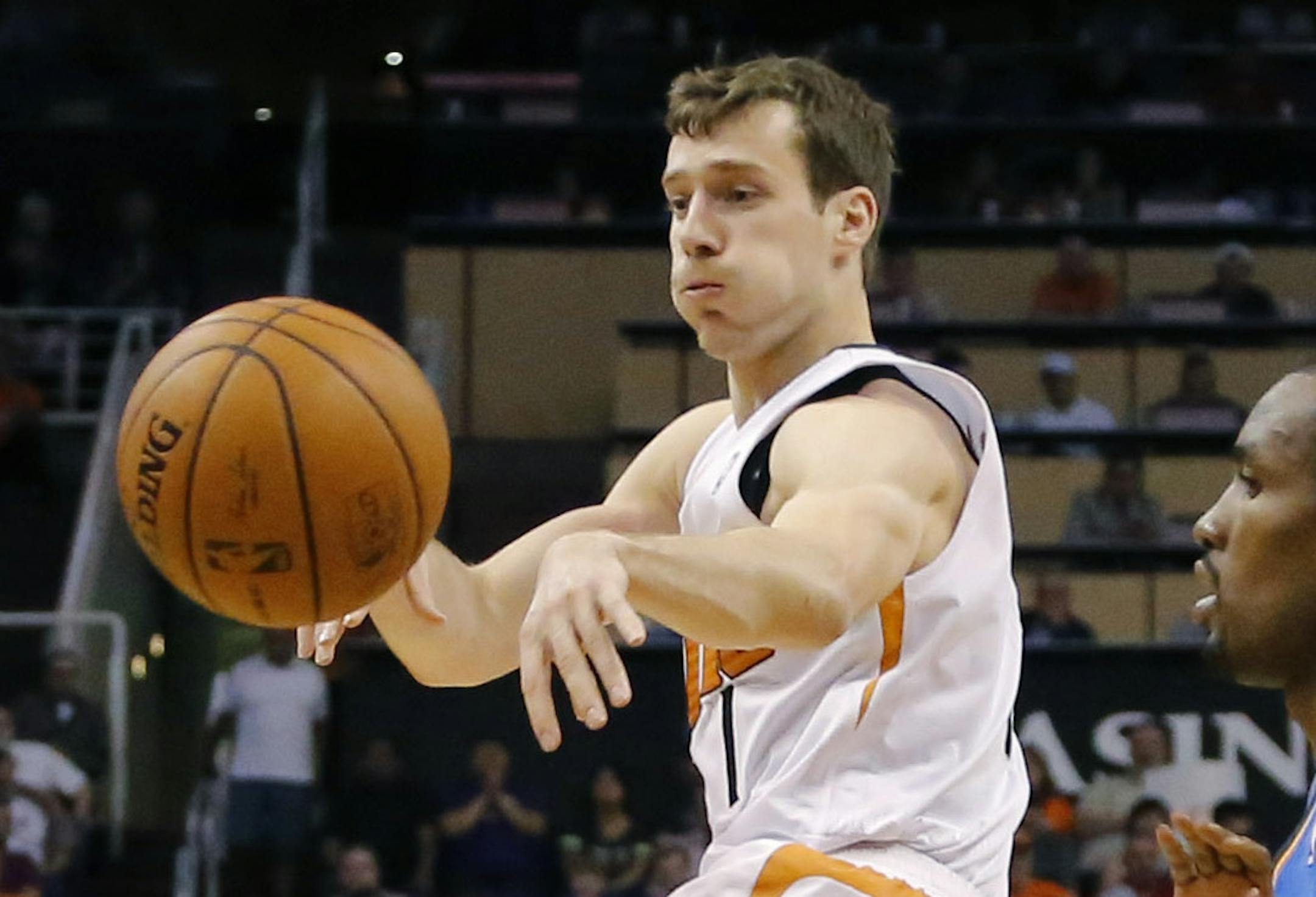 Phoenix Suns guard Goran Dragic (1), of Slovenia, dishes off as Oklahoma City Thunder forward Serge Ibaka, right, of Congo, defends, during the first half of an NBA basketball game on Sunday, April 6, 2014, in Phoenix. The Suns won 122-115. (AP Photo/Matt York)