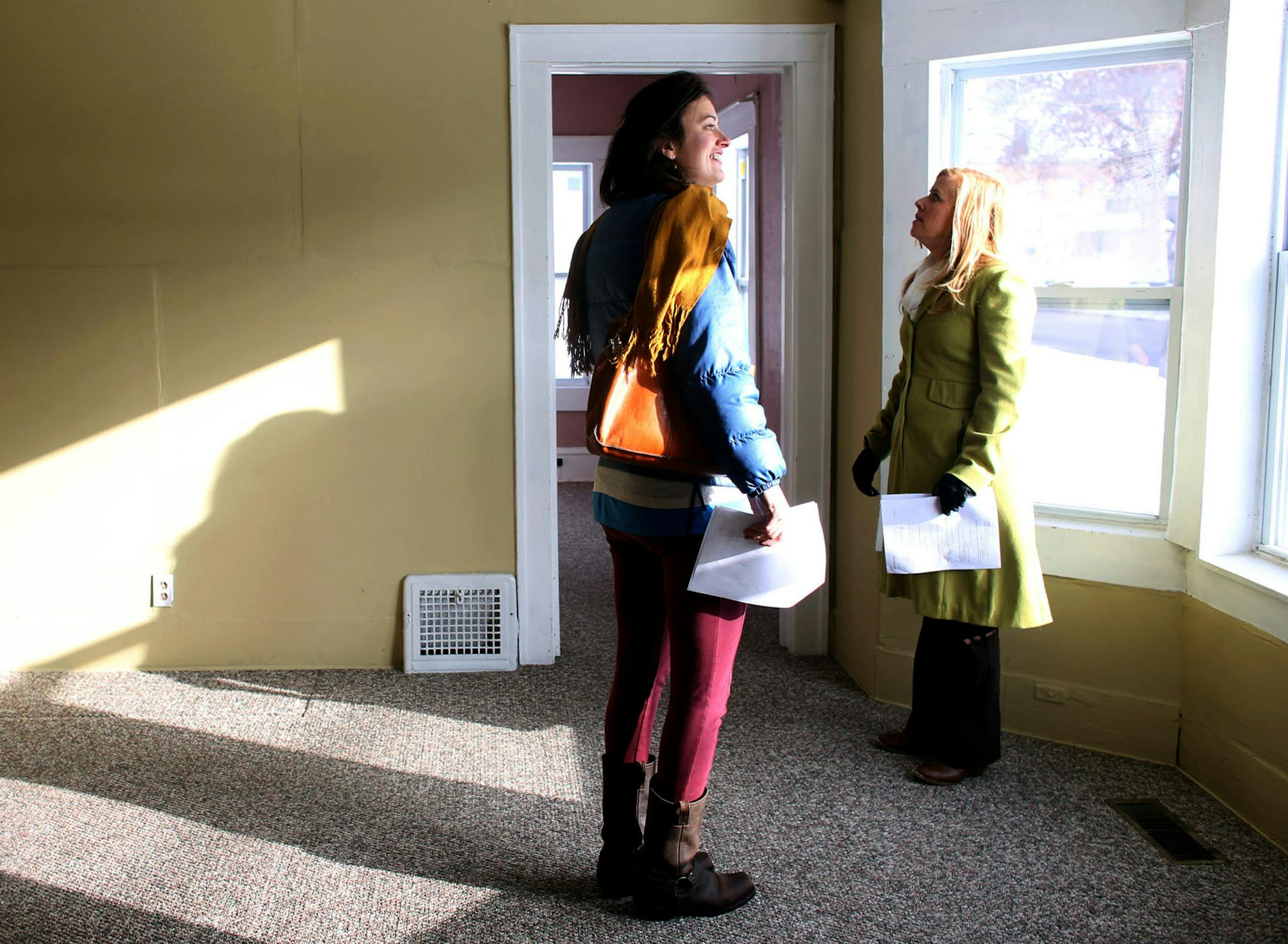 Real estate agent Emily Green, right, and potential home buyer Rishona Millard looked around the living room area of a house for sale on 5th Ave S in Minneapolis Saturday, January 11, 2014. ] (KYNDELL HARKNESS/STAR TRIBUNE) kyndell.harkness@startribune.com ORG XMIT: MIN1401131214241608